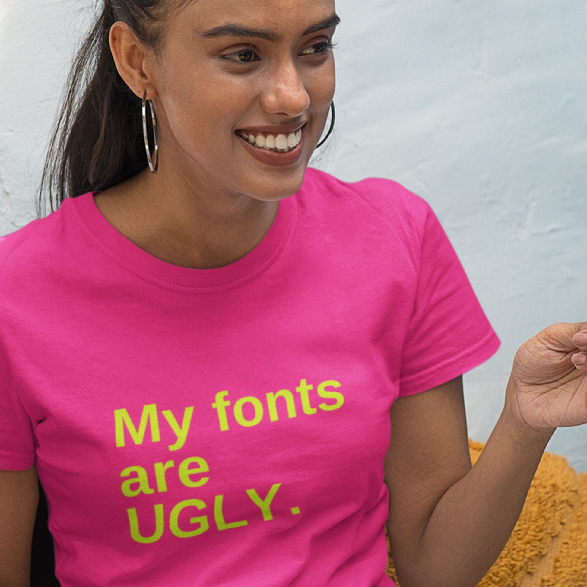 Woman wearing a pink t-shirt with 'My fonts are UGLY.' text.
