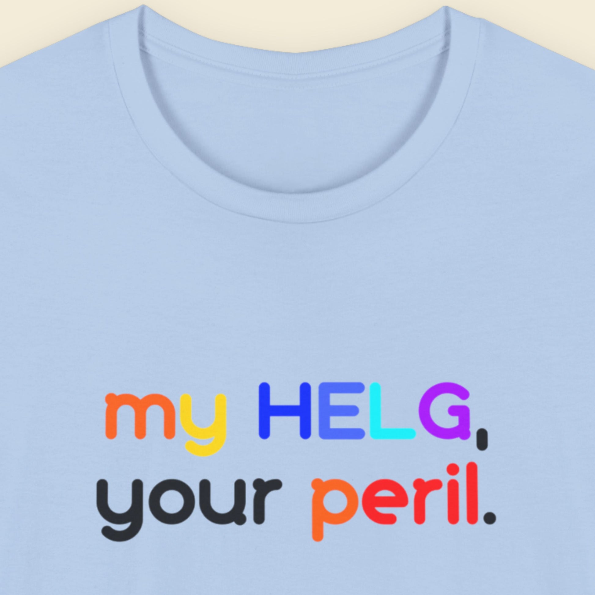 Light blue t-shirt with colorful Swedish text design on a beige background.