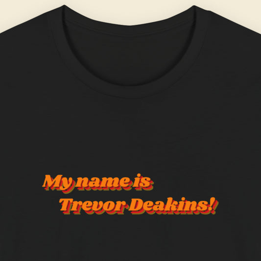 Black t-shirt with red text 'My name is Trevor Deakins!' on a beige background