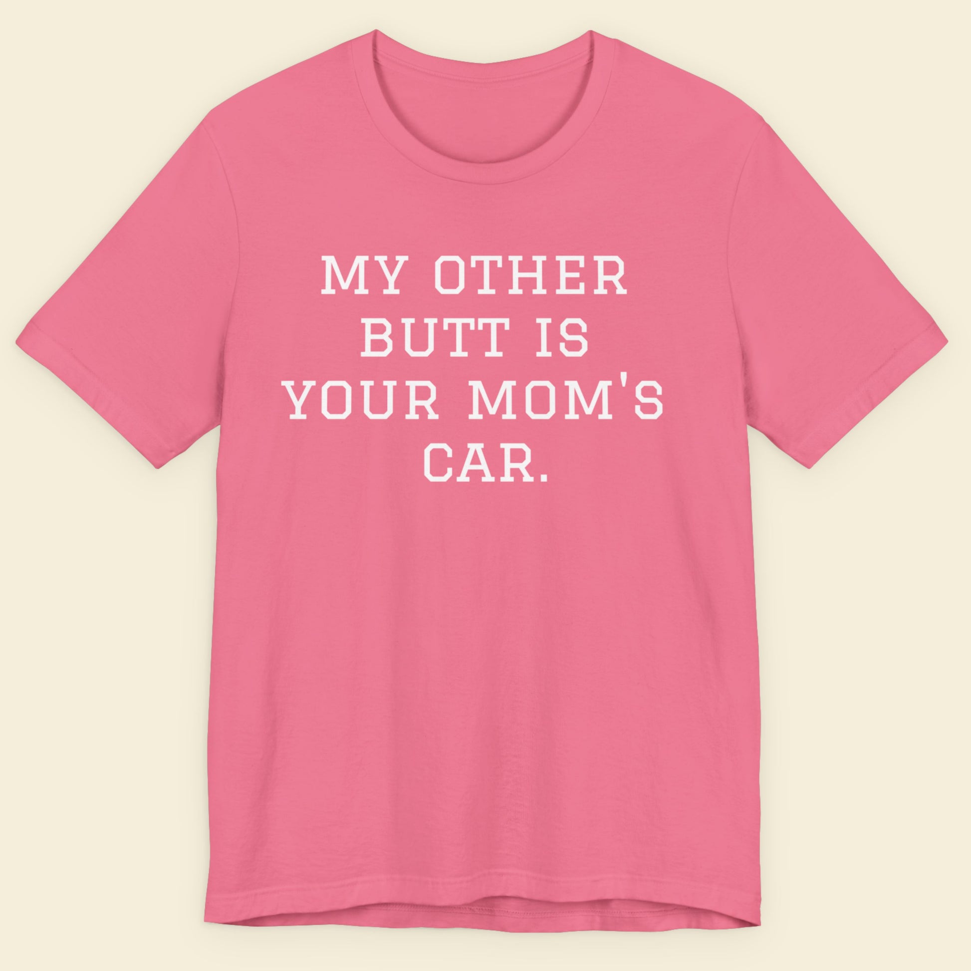 Pink t-shirt with white text on a beige background.
