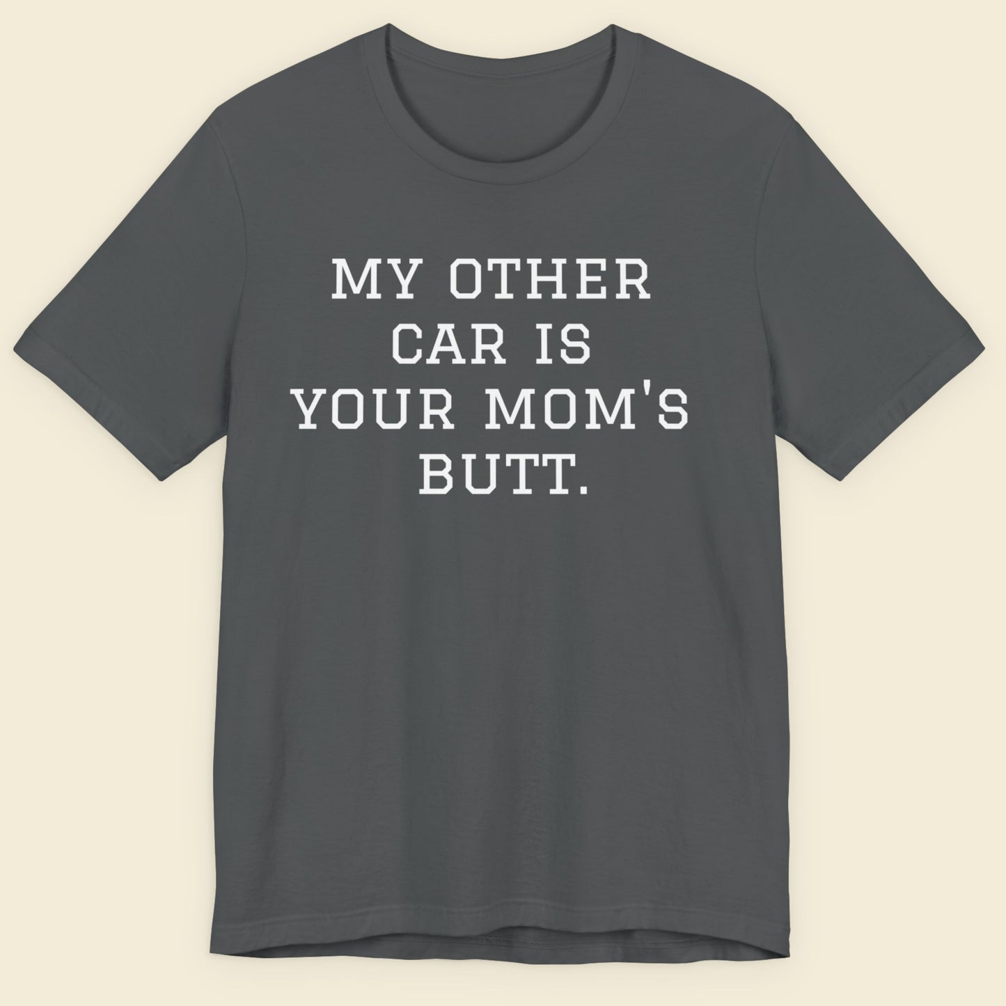 Gray t-shirt with humorous text on a beige background.