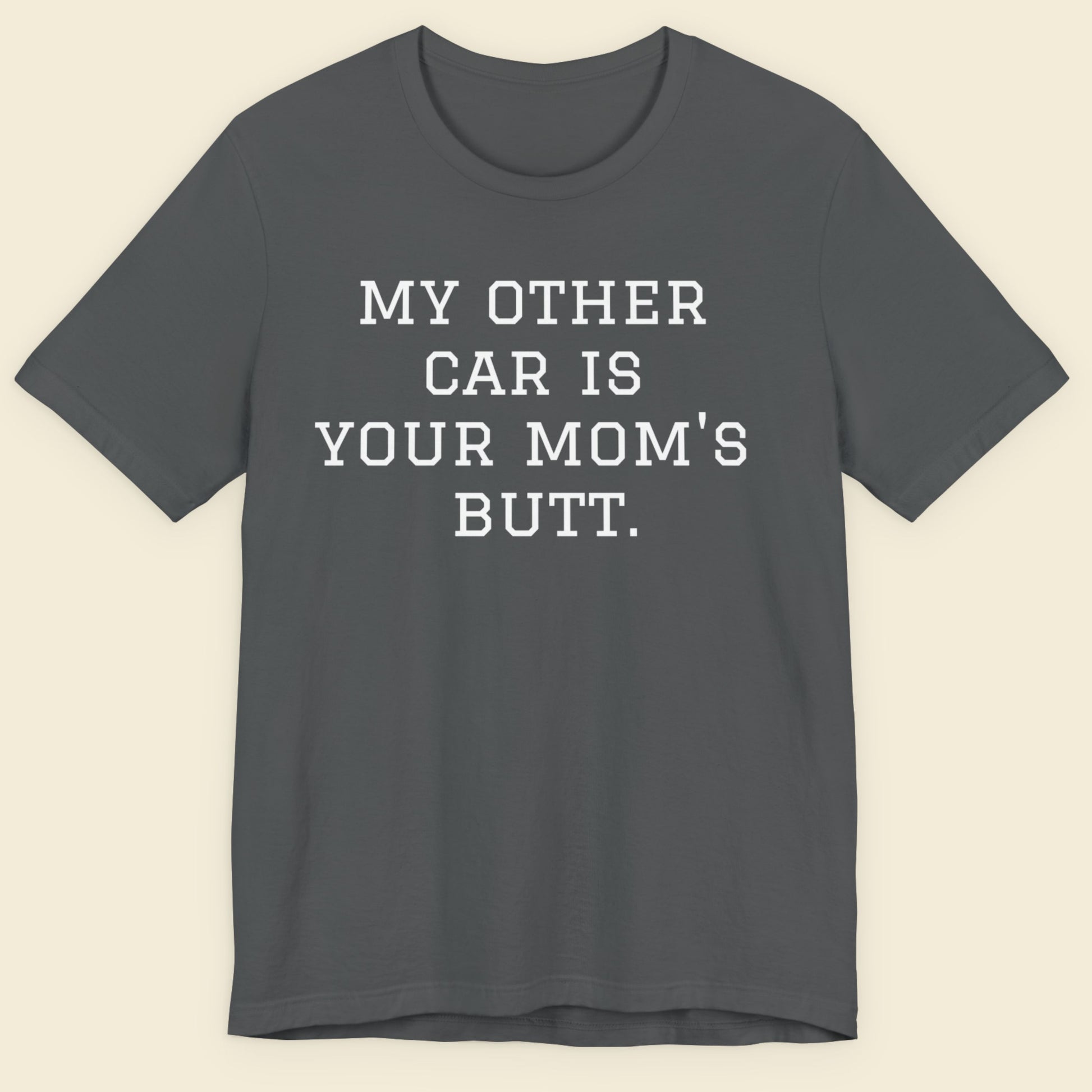 Gray t-shirt with humorous text on a beige background.