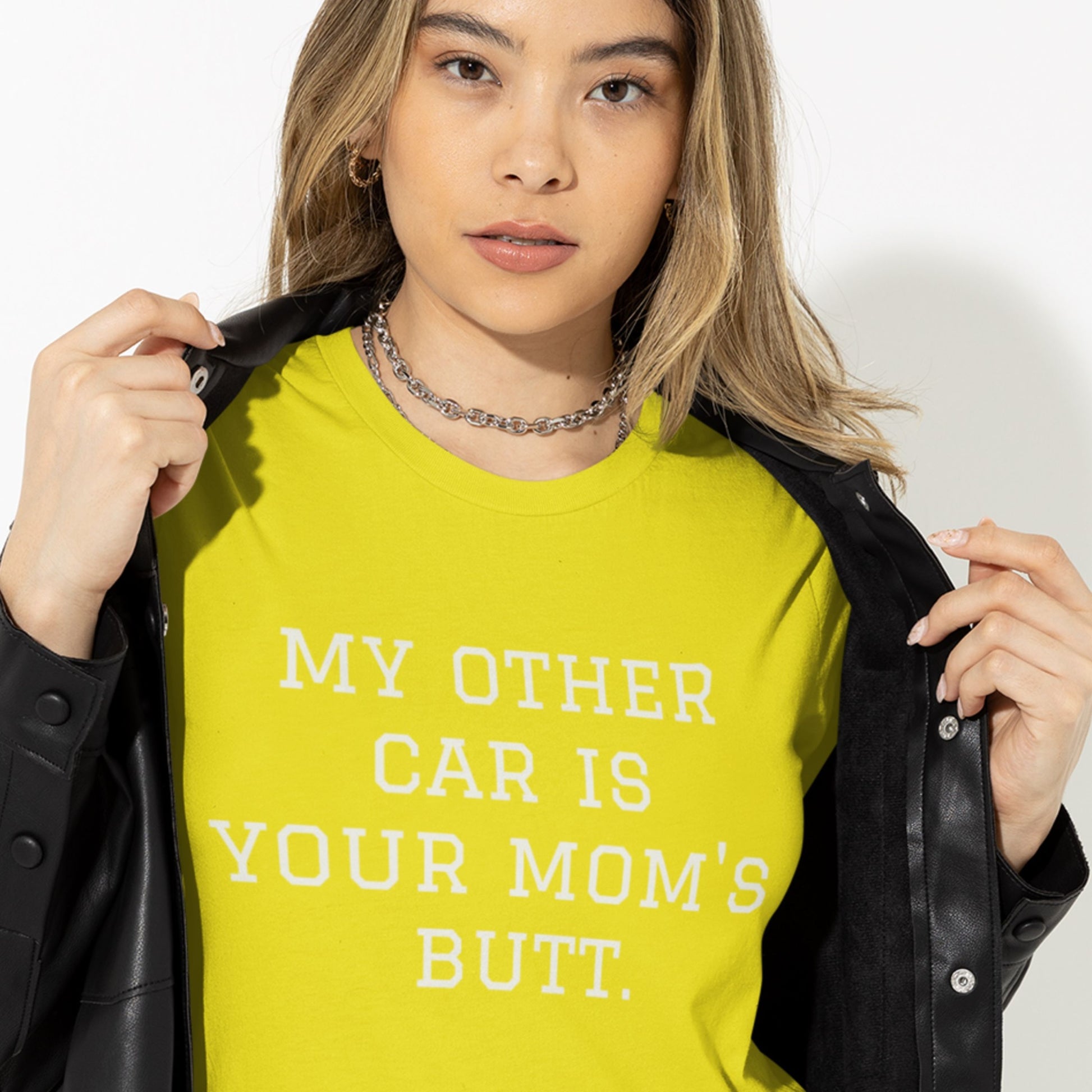 Person wearing a yellow shirt with text, holding a black jacket.
