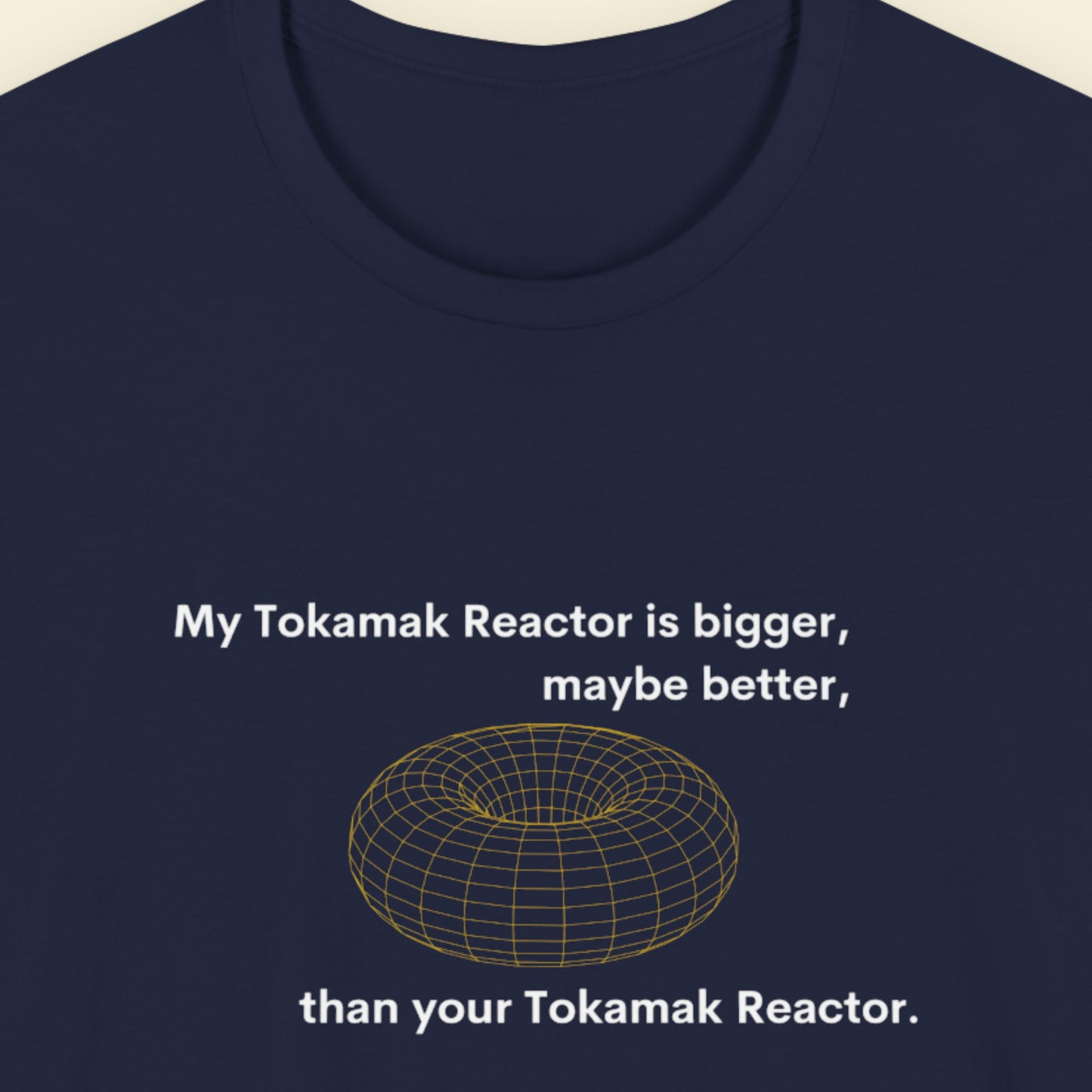 Navy blue t-shirt with text and graphic of a tokamak reactor on a beige background.
