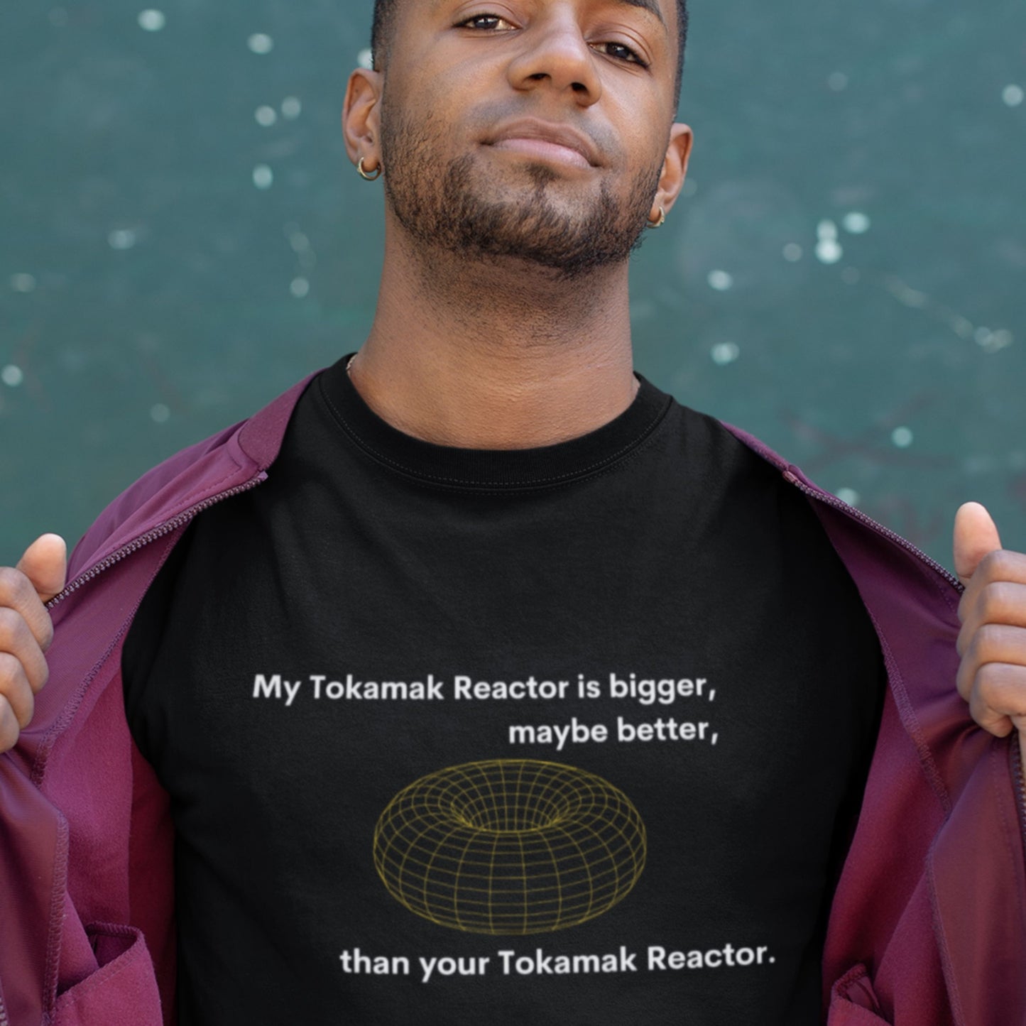 Person wearing a black t-shirt with a graphic and text about a Tokamak Reactor, against a dark background.