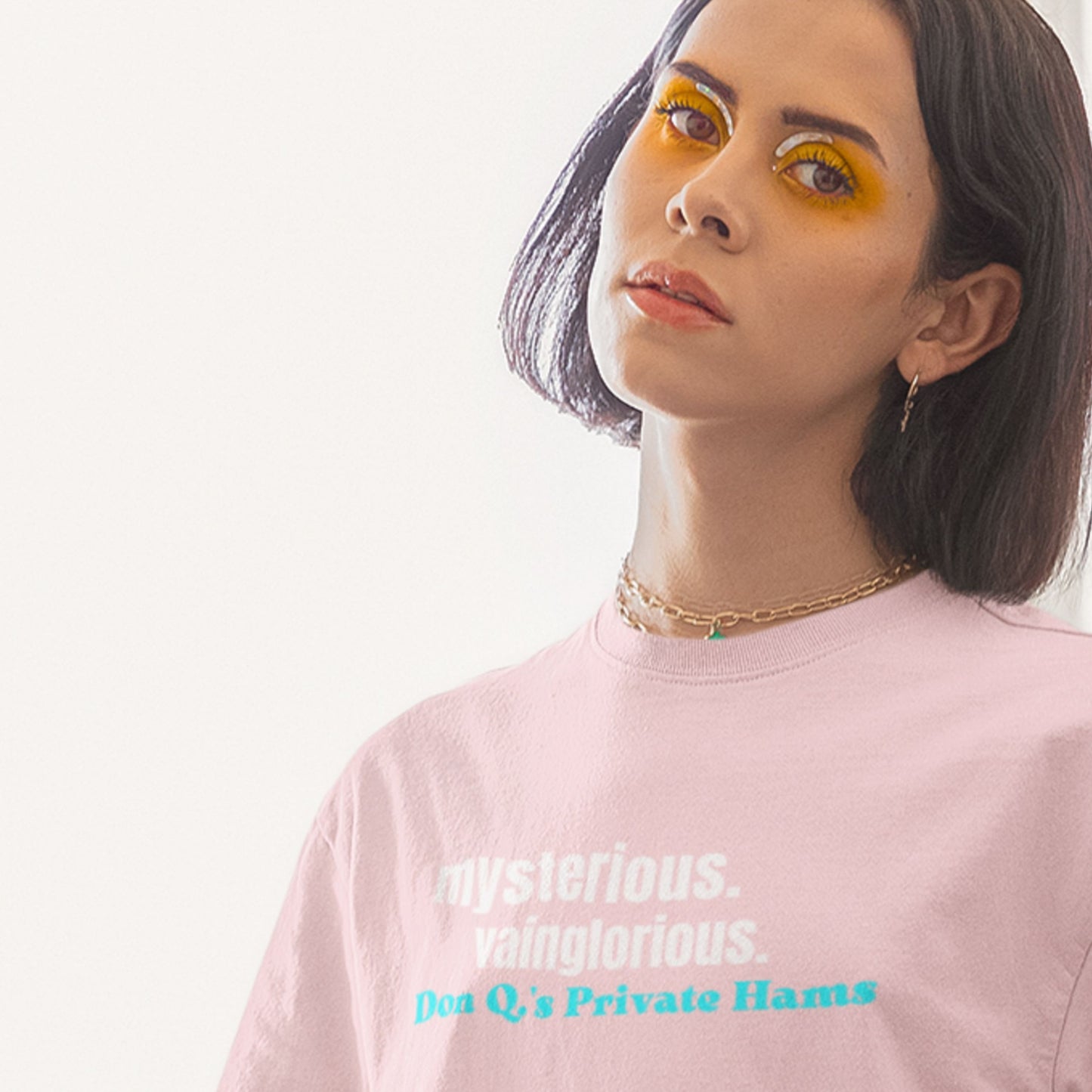Person wearing a pink t-shirt with text on a plain background.