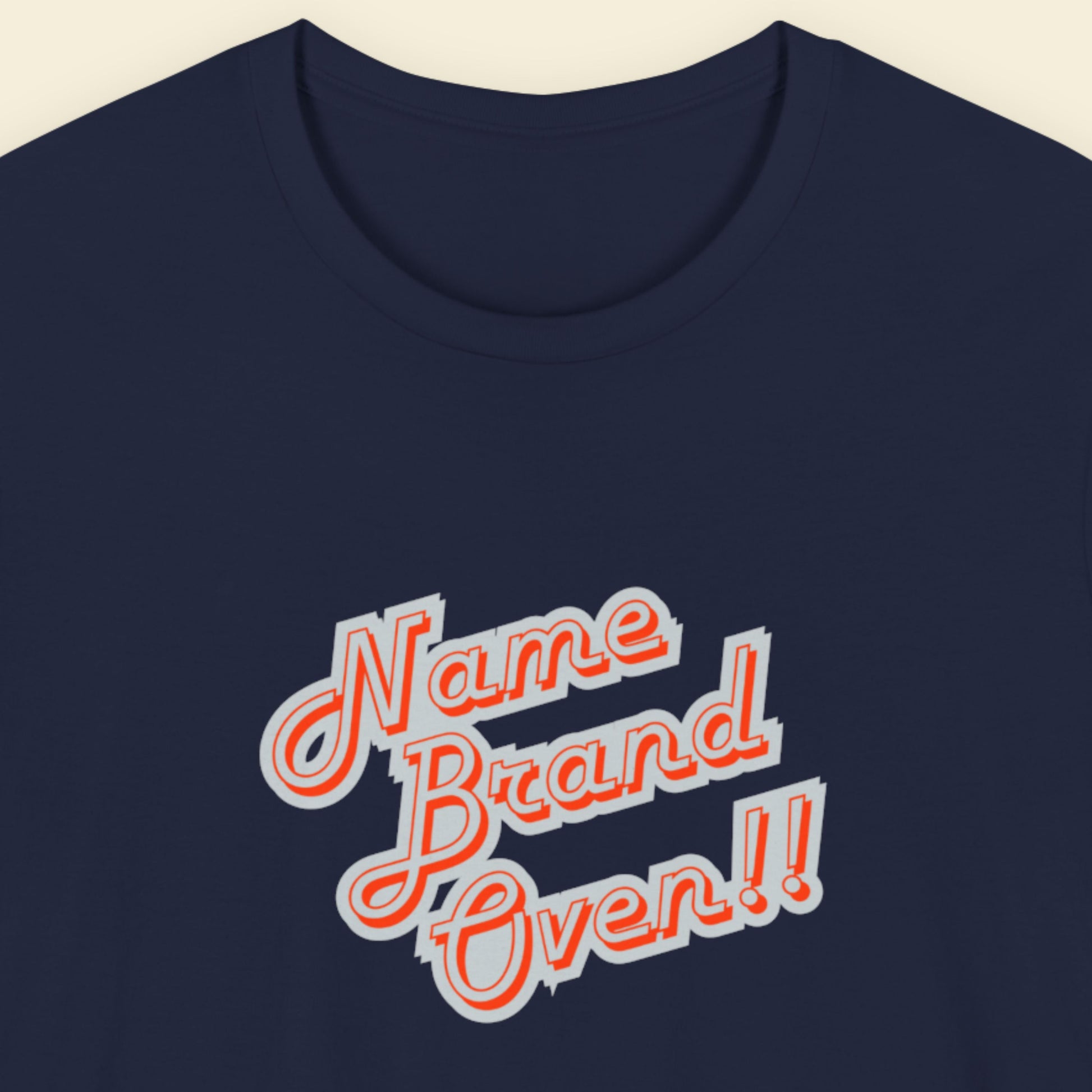 Navy blue t-shirt with 'Name Brand Oven!!' text in red and white on a beige background.