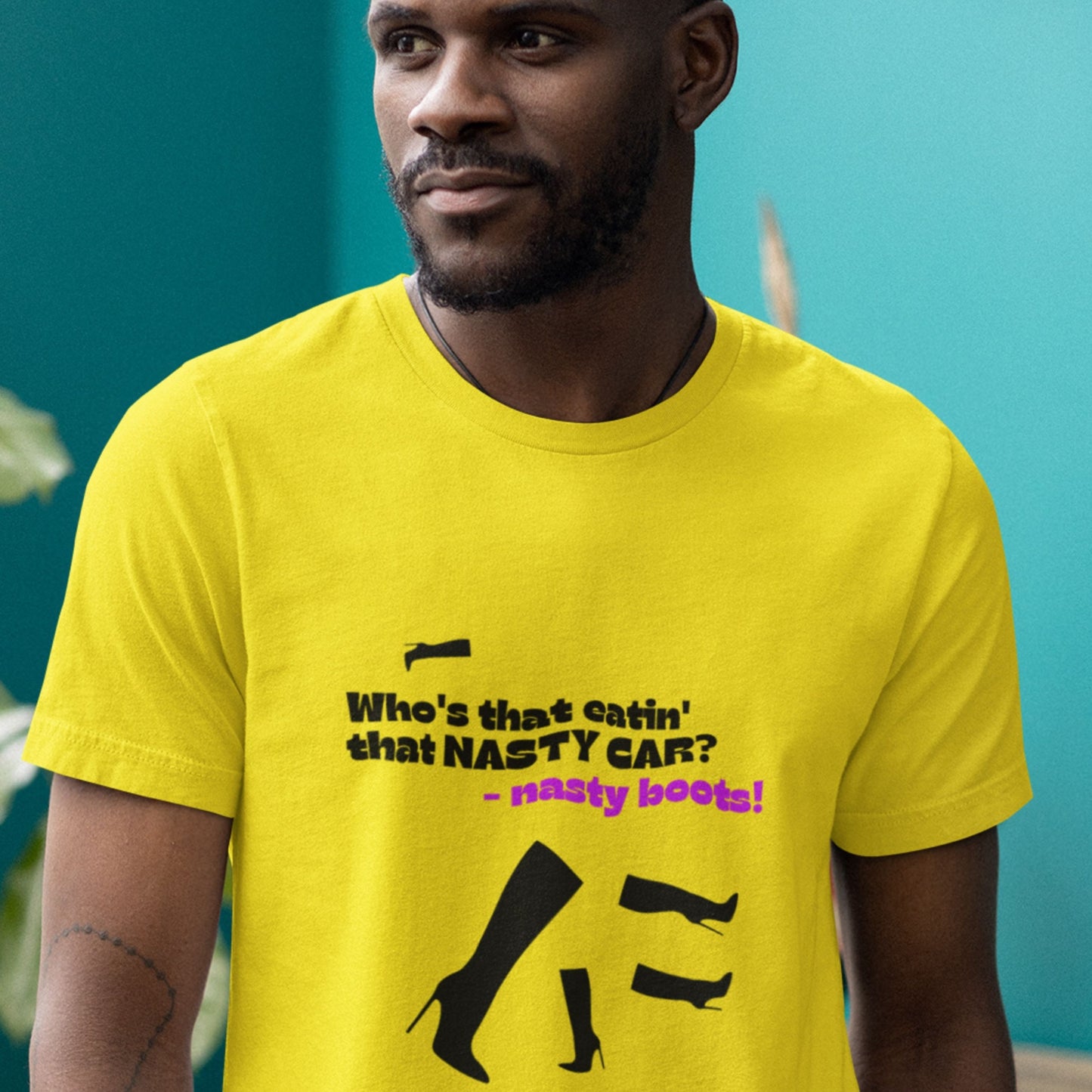 Man wearing a yellow t-shirt with text and graphics against a teal background.