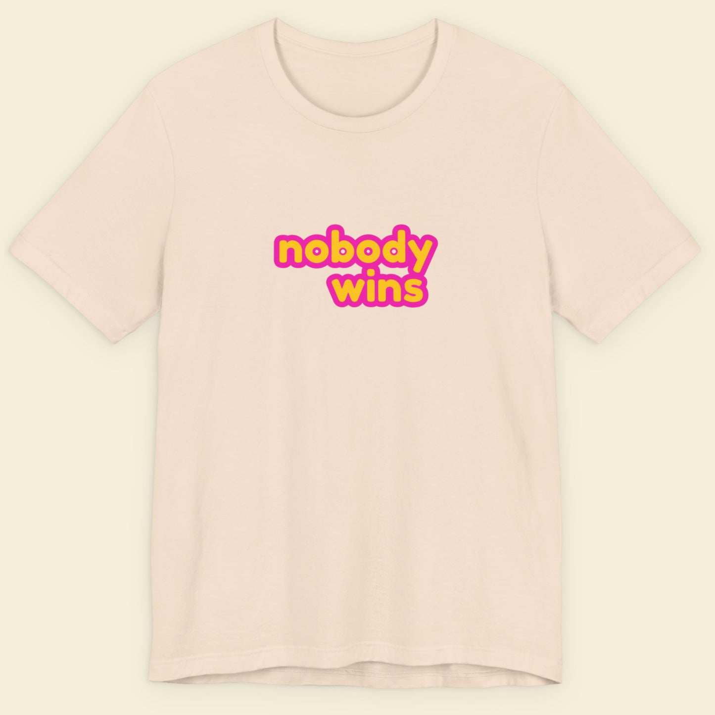 Beige t-shirt with 'nobody wins' text in yellow and pink on a light beige background