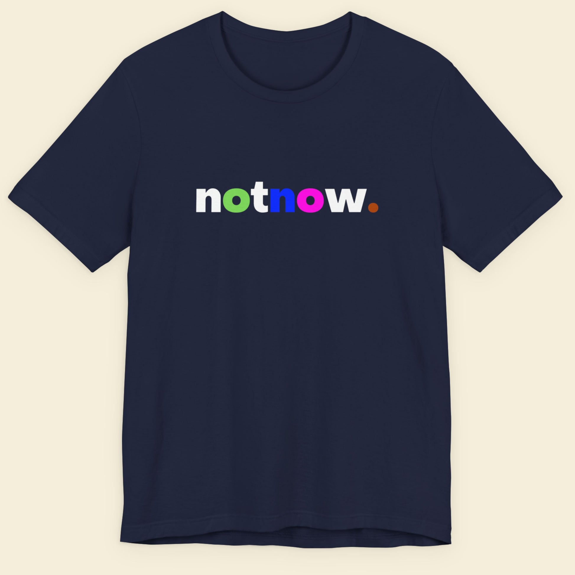 Navy blue t-shirt with 'notnow' text in multicolor on a beige background.