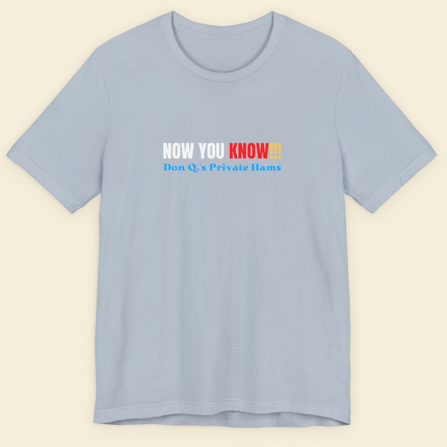 Light blue t-shirt with multicolored 'now you know!!!' text on a beige background.