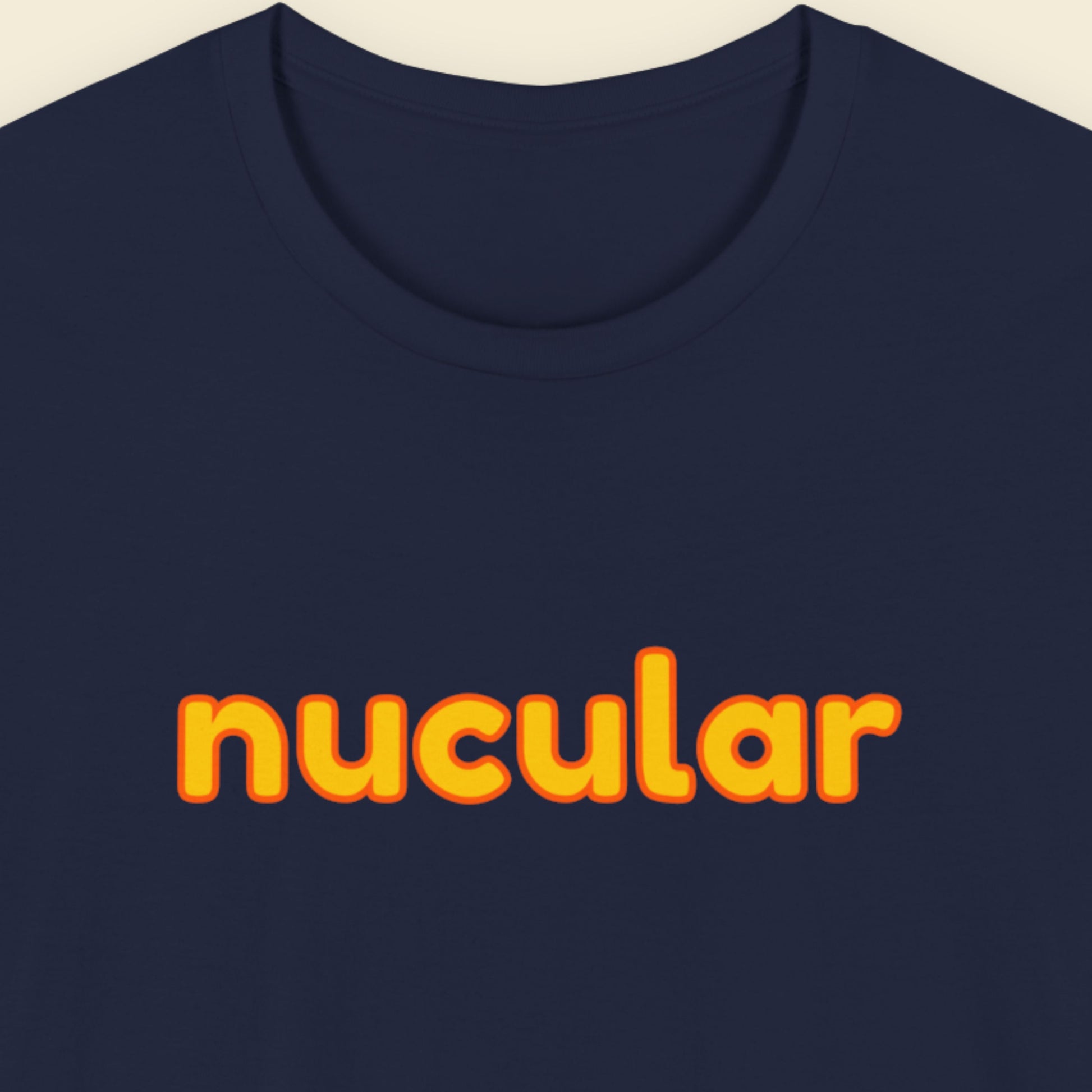 Navy blue t-shirt with humorous colorful text on a beige background.