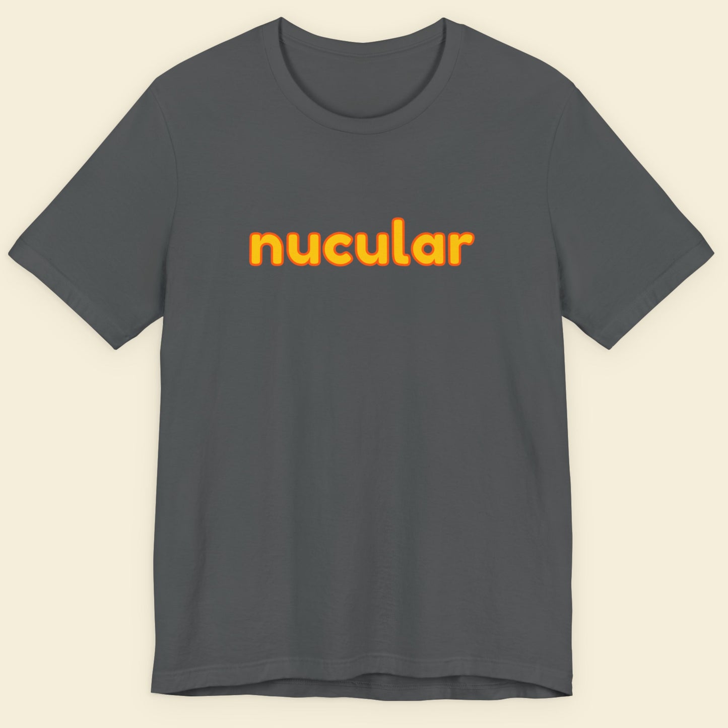 Grey t-shirt with humorous colorful text on a beige background.
