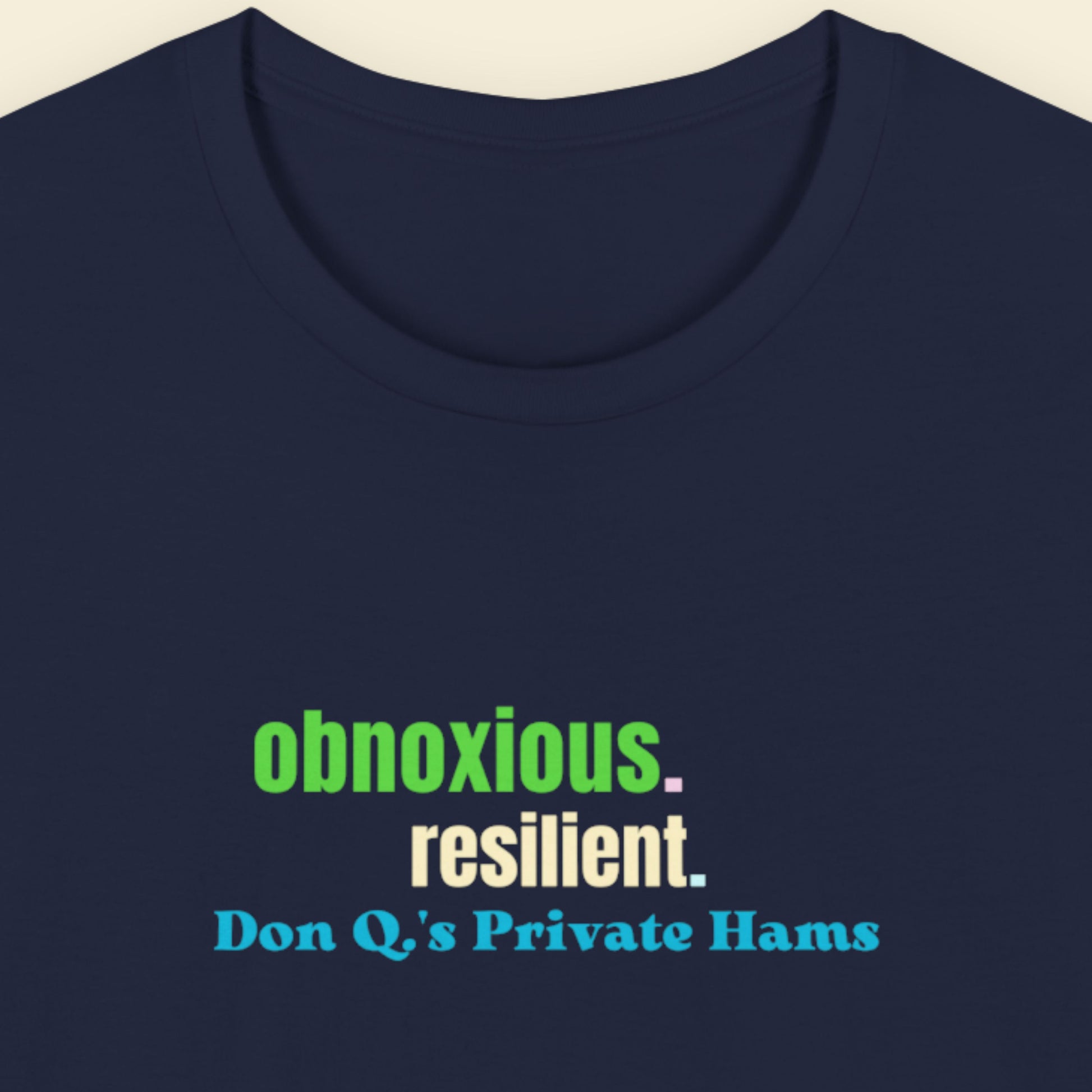 Navy t-shirt with humorous colorful text on a beige background.
