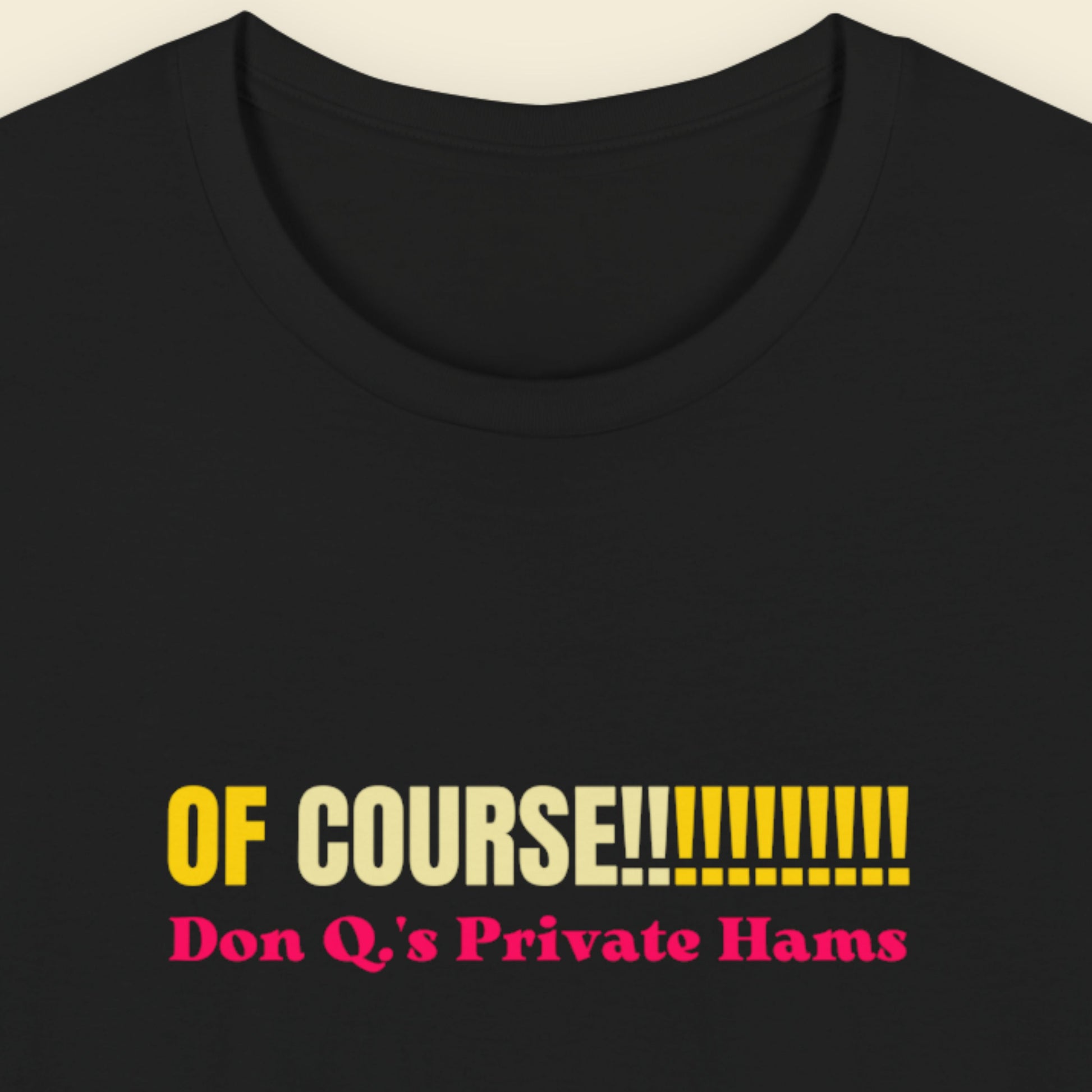 Black tee with multicolored 'of course!!!!!!!!!!!' text on a beige background.