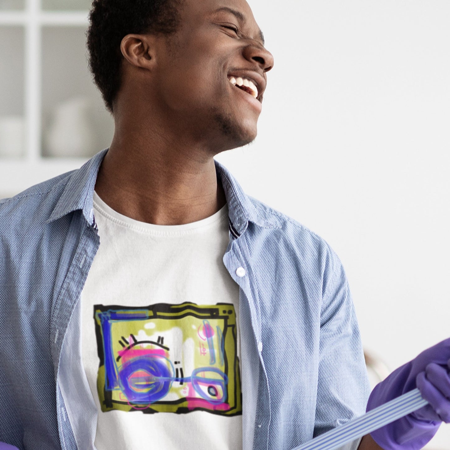 Man in a cleaning products commercial wearing a white t-shirt with a colorful abstract drawing in a kitchen.