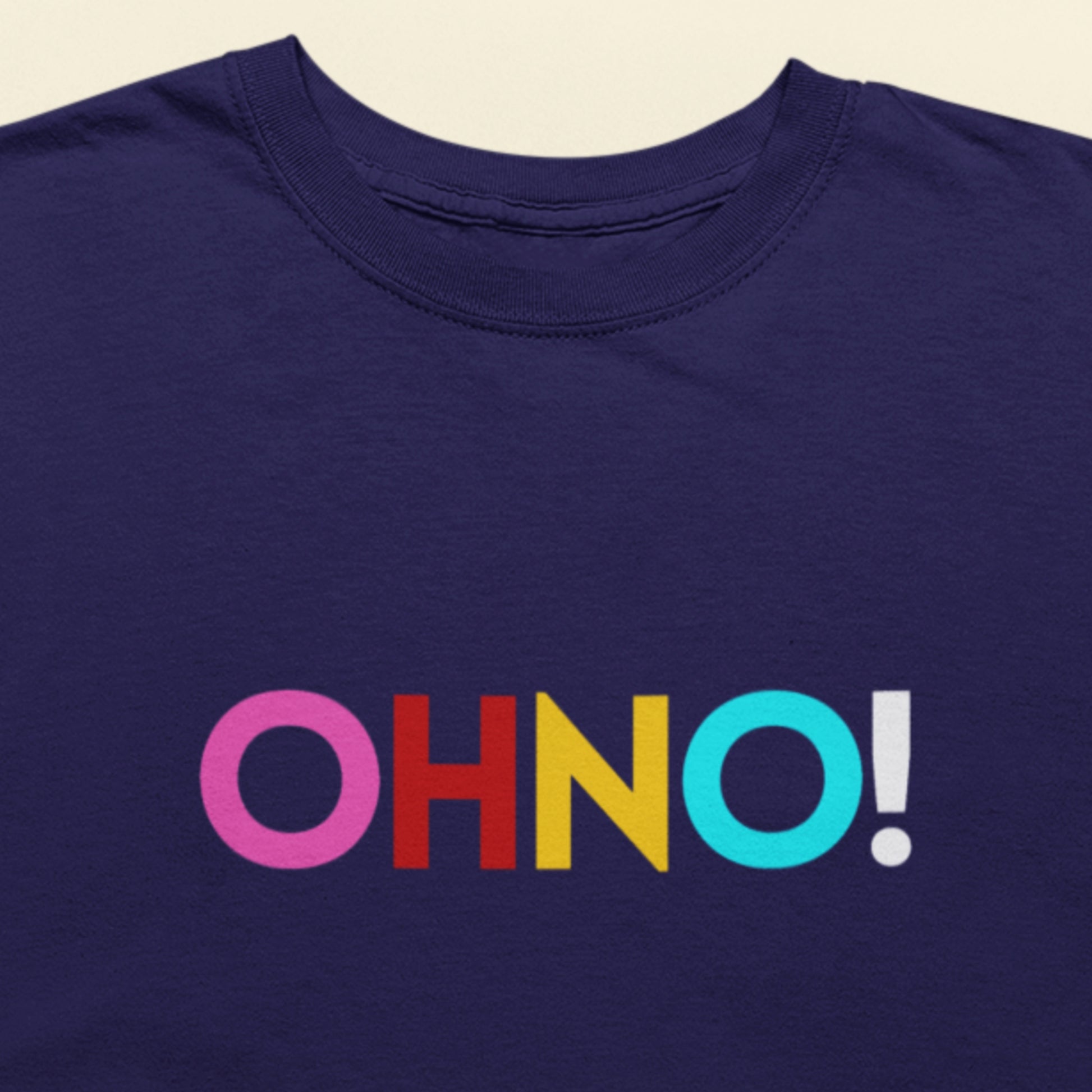 Navy blue t-shirt with colorful 'OHNO!' text on a beige background