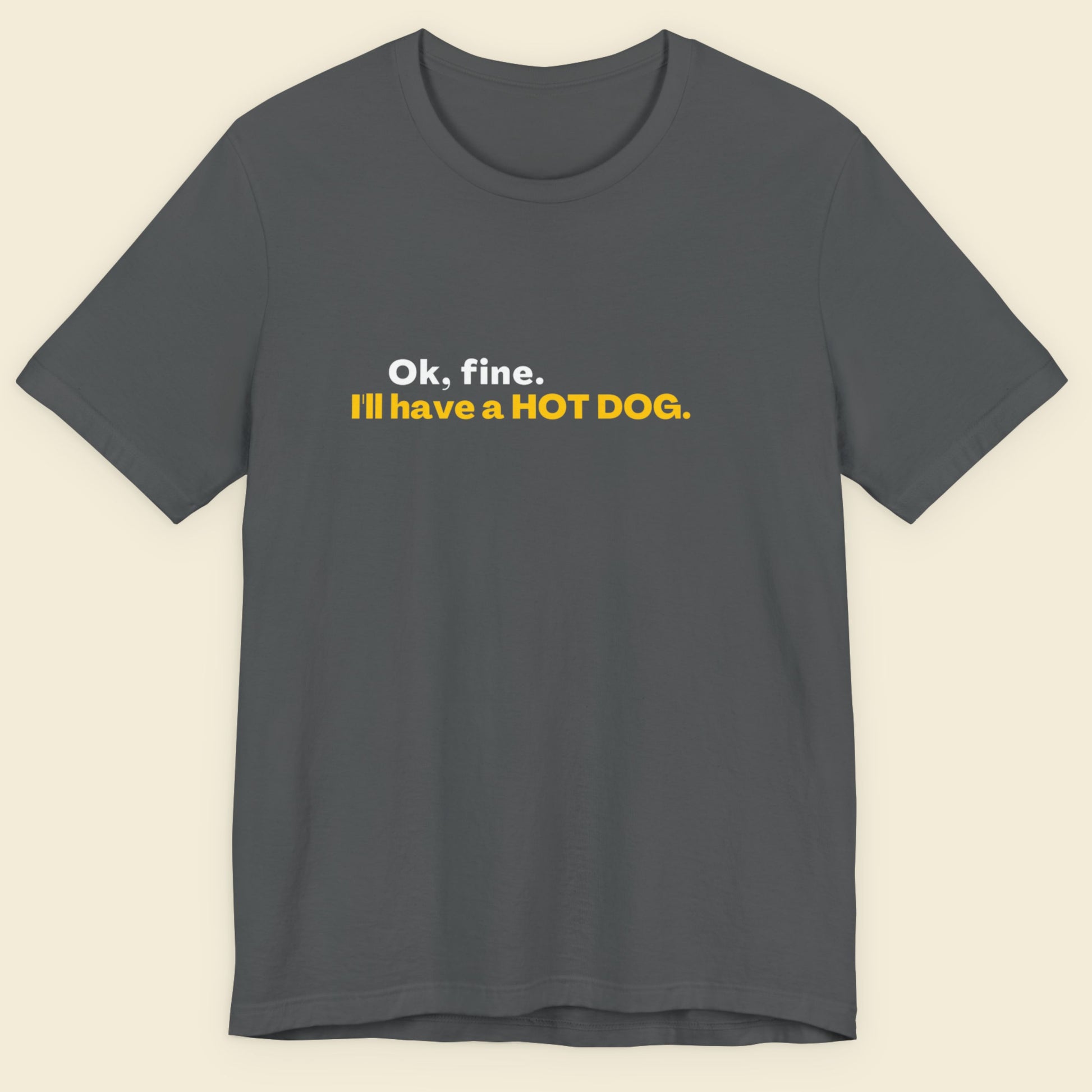 Gray t-shirt with yellow text on a beige background.