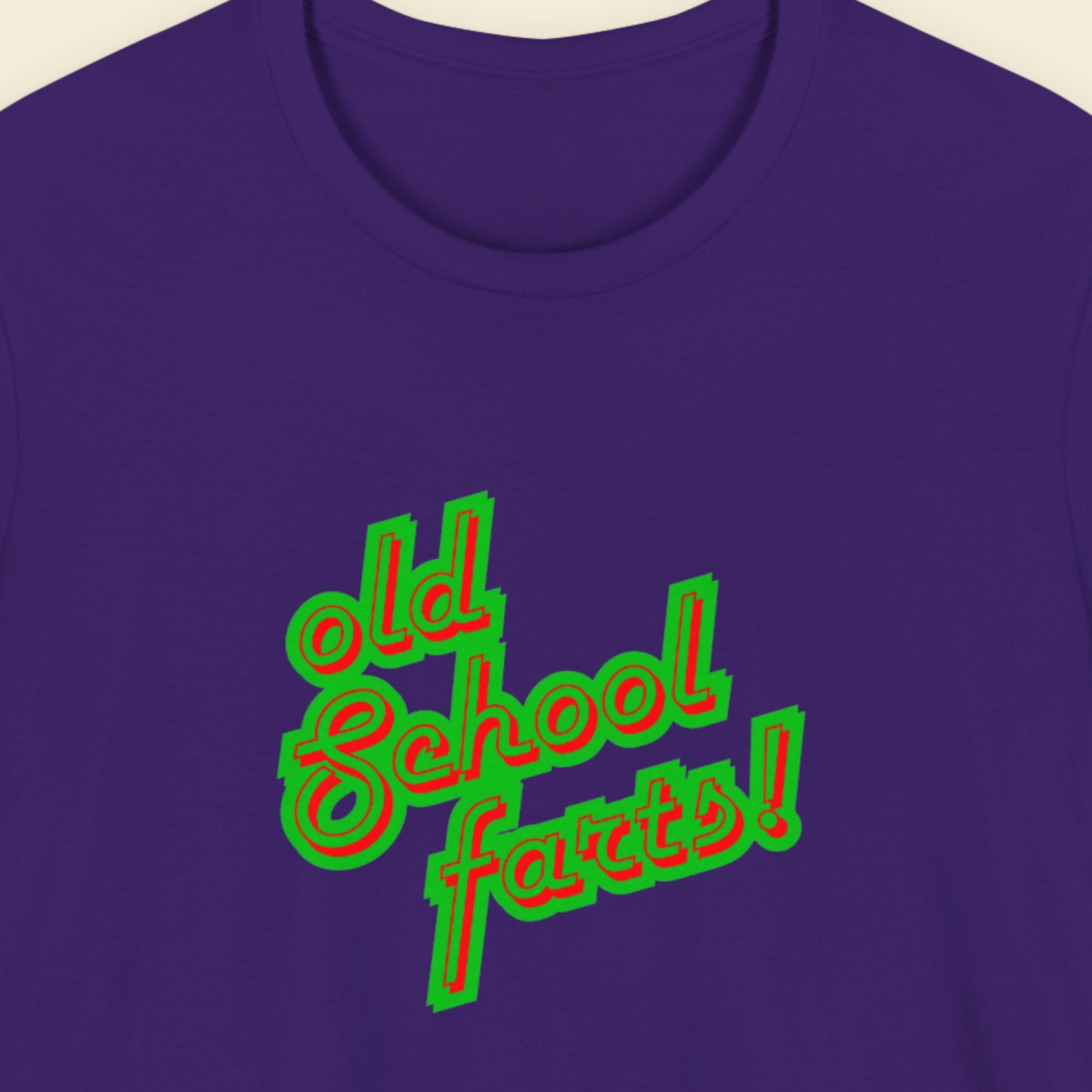 Navy t-shirt with humorous colorful text on a beige background.