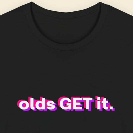 Black t-shirt with colorful text 'olds GET it.' on a beige background.