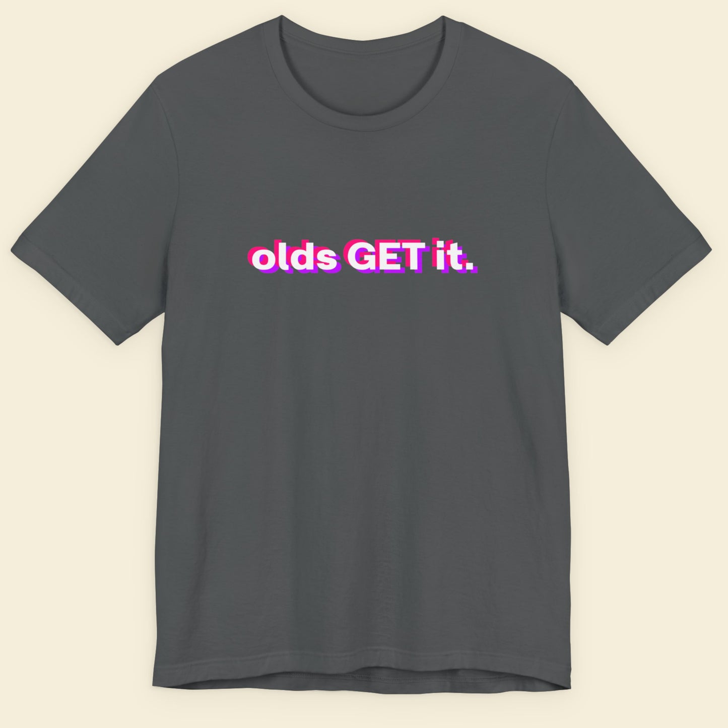 Gray t-shirt with 'olds GET it.' text in pink and white on a beige background.