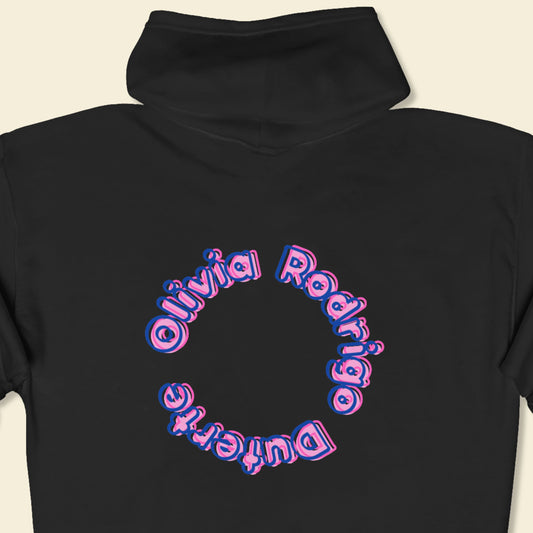 Black hoodie with 'Olivia Rodrigo Duterte' text in a circular design on a beige background.