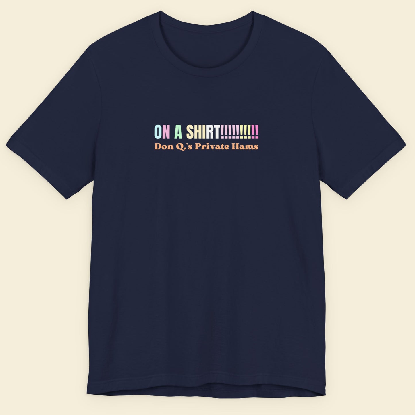 Navy blue t-shirt with colorful text on a beige background.