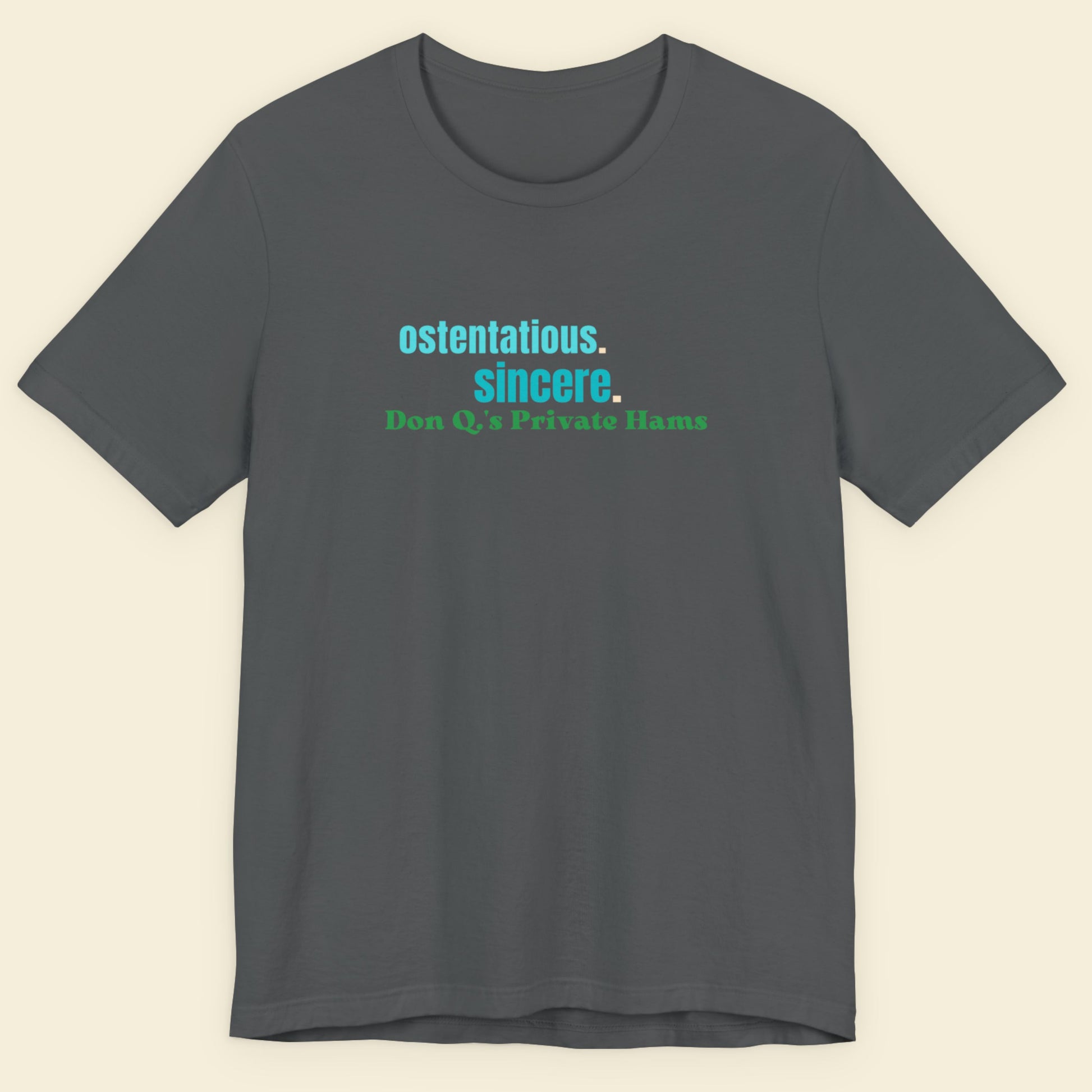 Gray t-shirt with text 'ostentatious. sincere. Don Q's Private Hams' on a beige background.