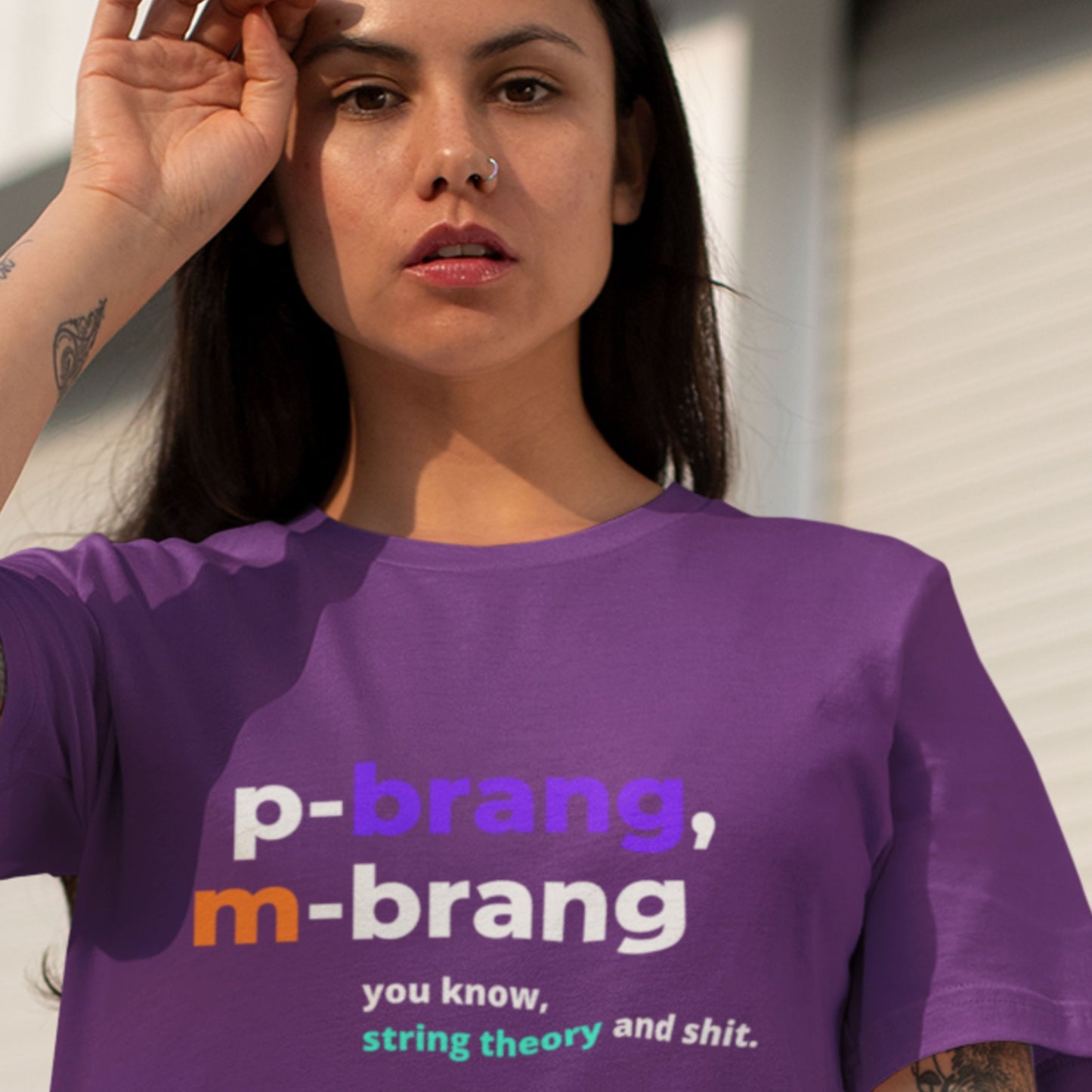 Person wearing a purple t-shirt with text, standing outdoors.