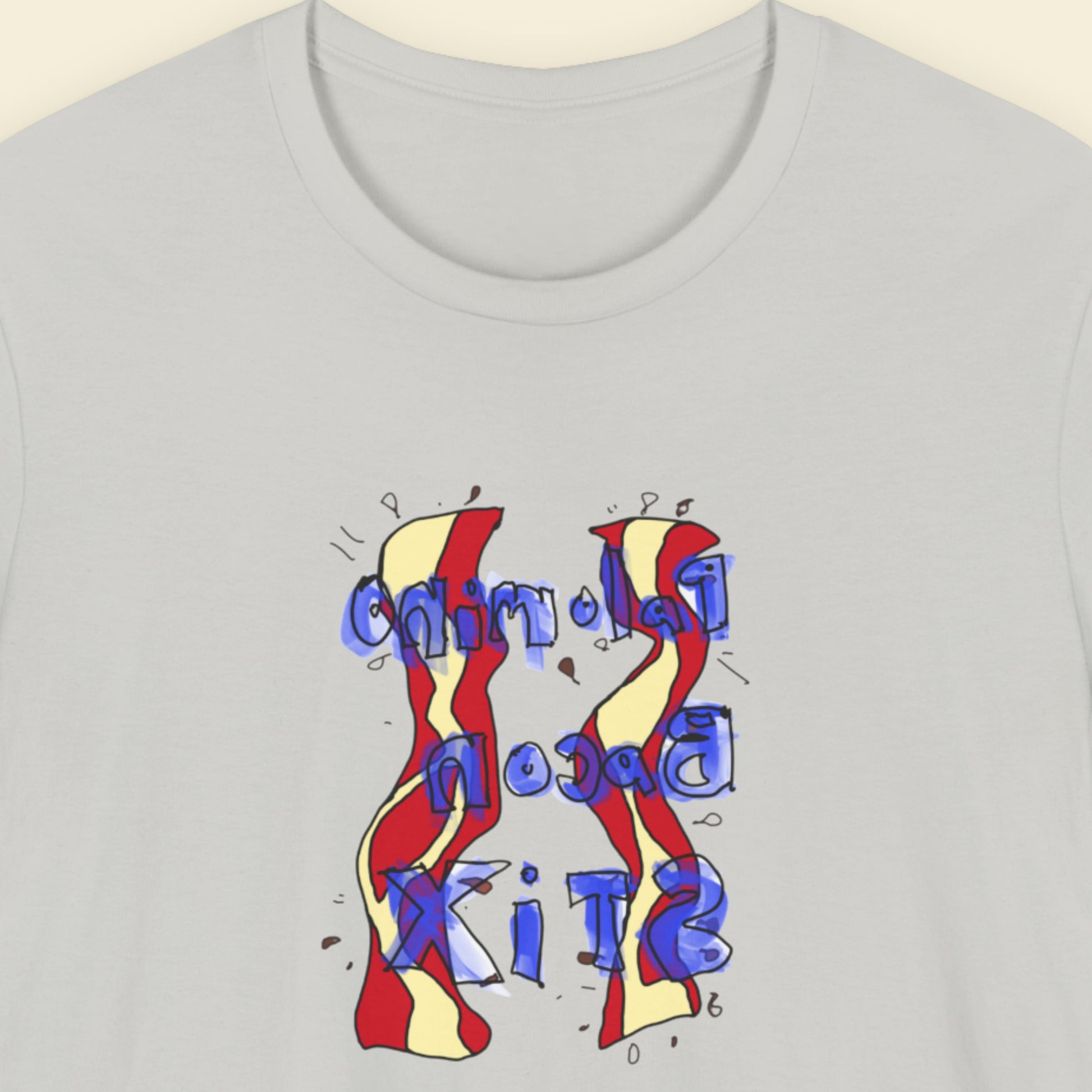 Grey t-shirt with a colorful abstract bacon drawing on a beige background.