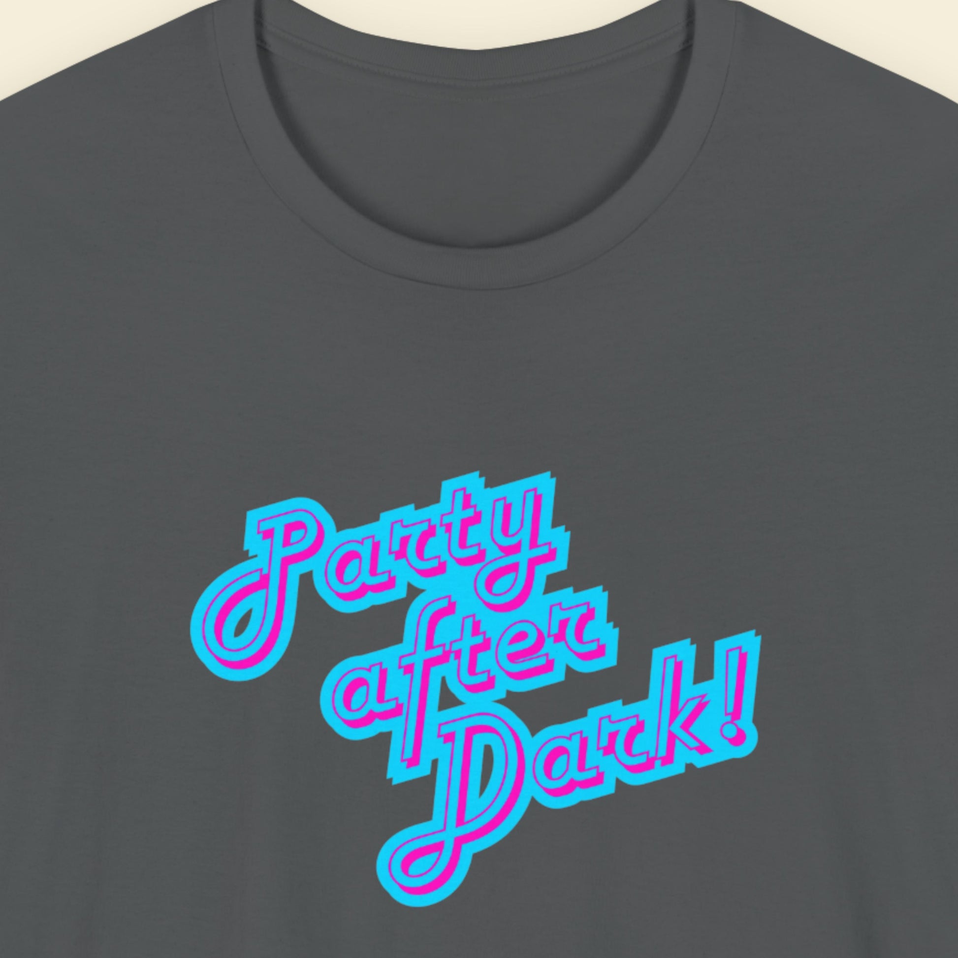 Dark grey t-shirt with humorous colorful text on a beige background.