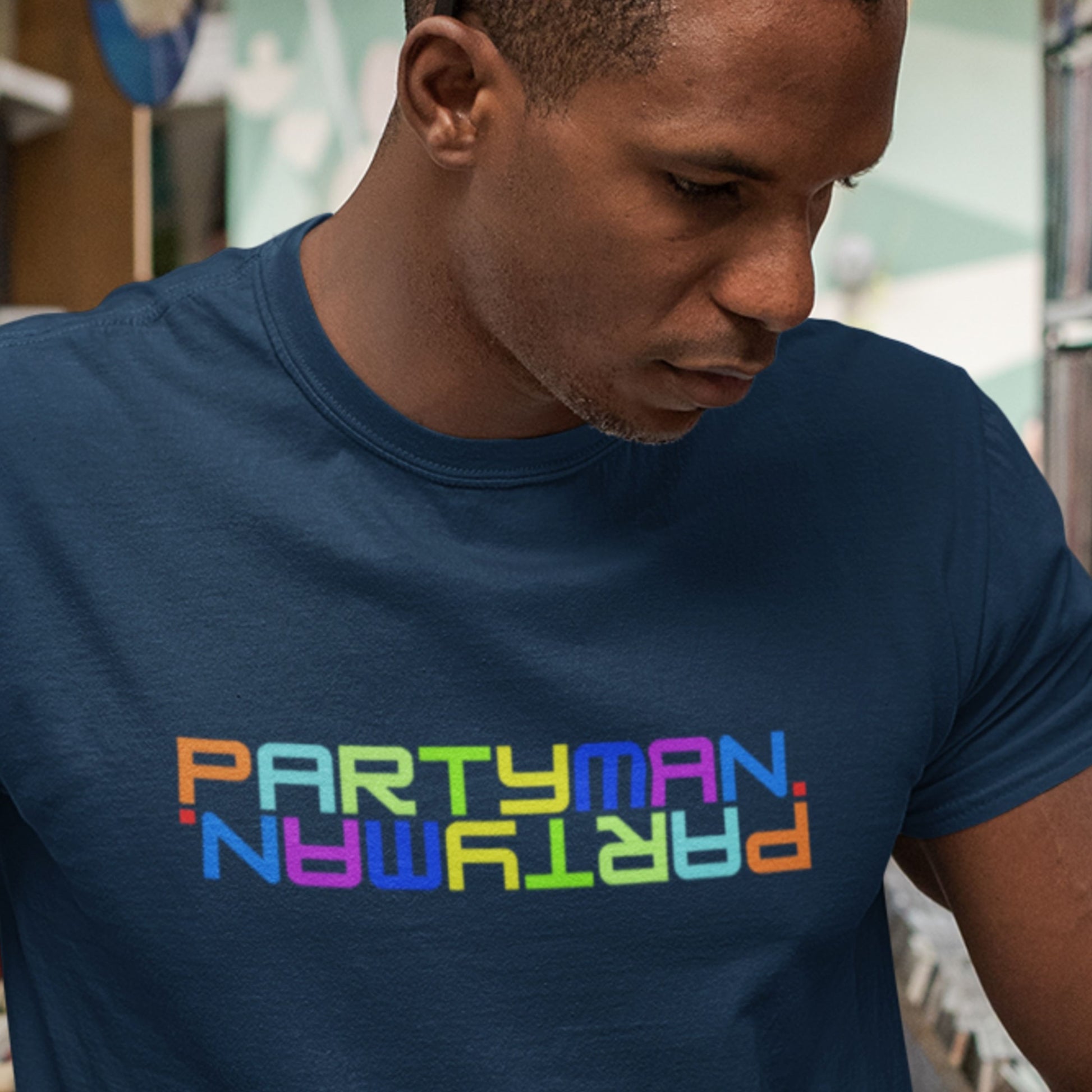 Man wearing a navy blue t-shirt with 'PARTYMAN' in colorful letters.