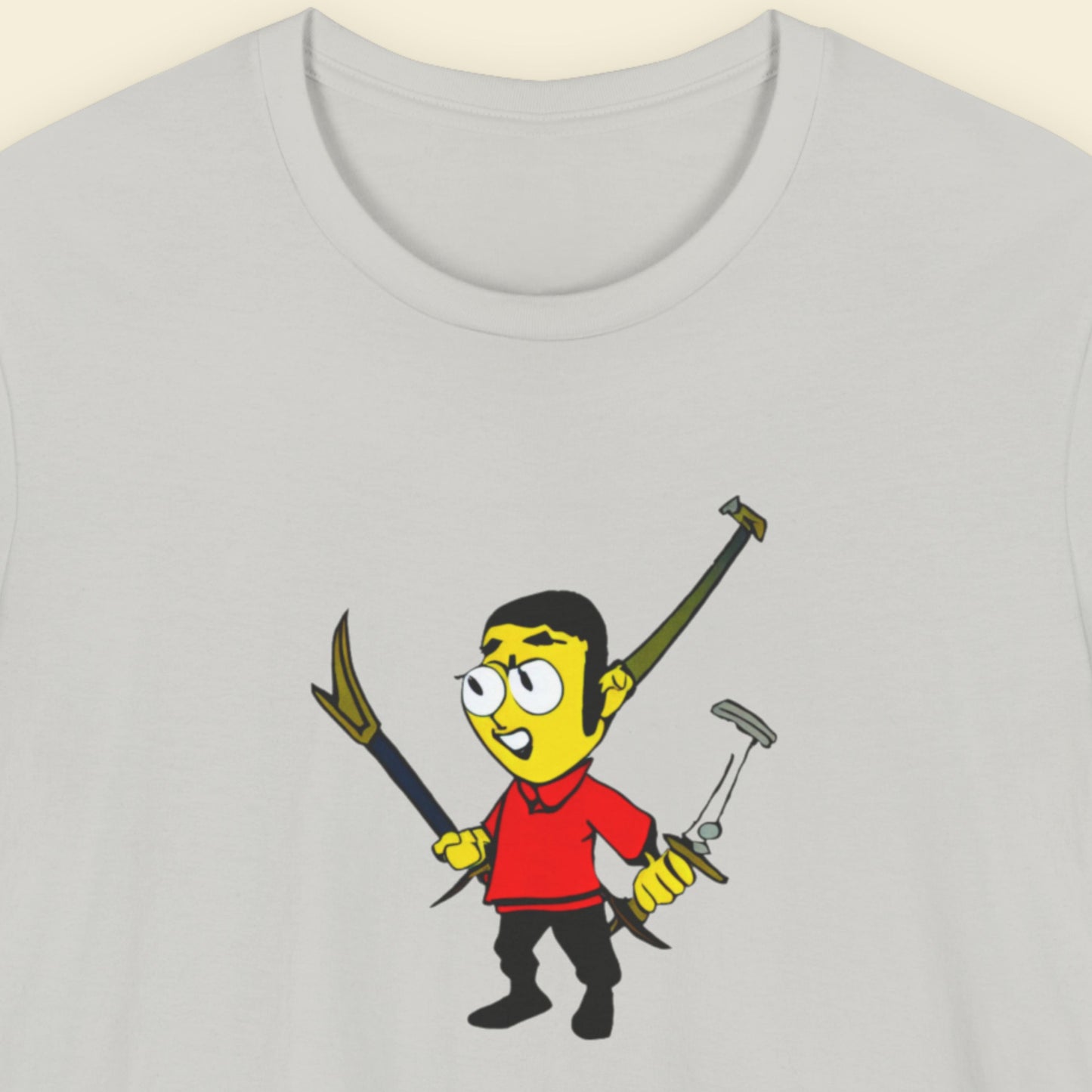 Light grey tee with a fun, colorful cartoon illustration on a beige background.
