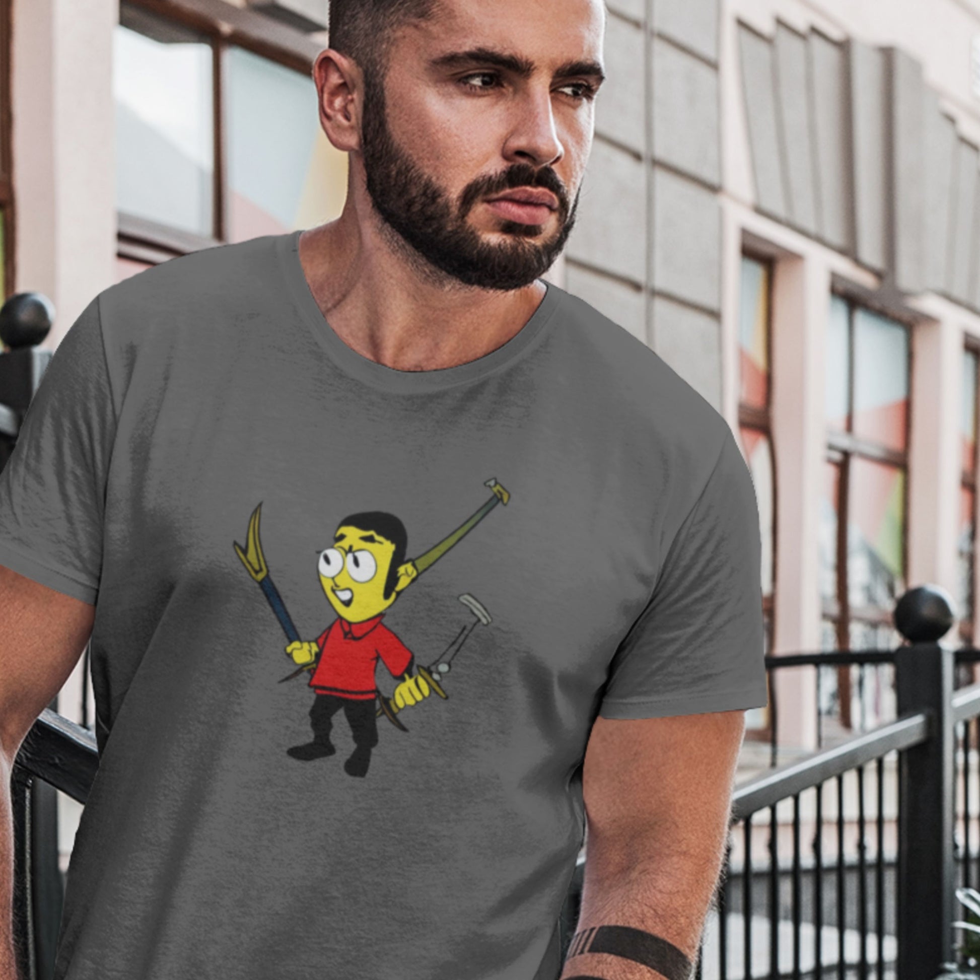 Pensive man wearing a dark grey tee with a fun, colorful cartoon illustration on a stoop.