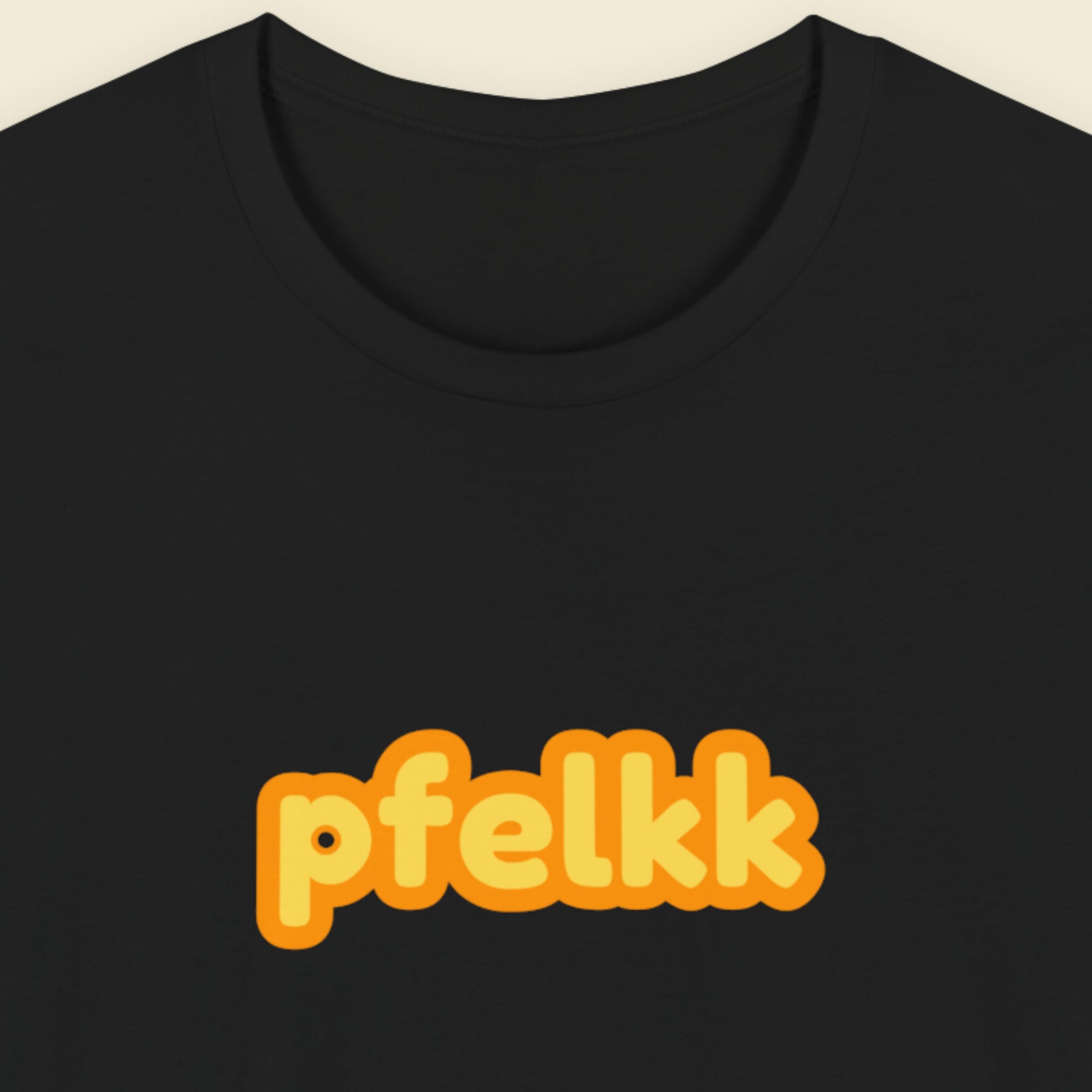 Black tee with multicolored 'pfelkk' text on a beige background.