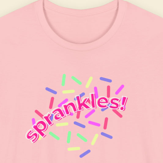 Pink t-shirt with humorous colorful text on a beige background.