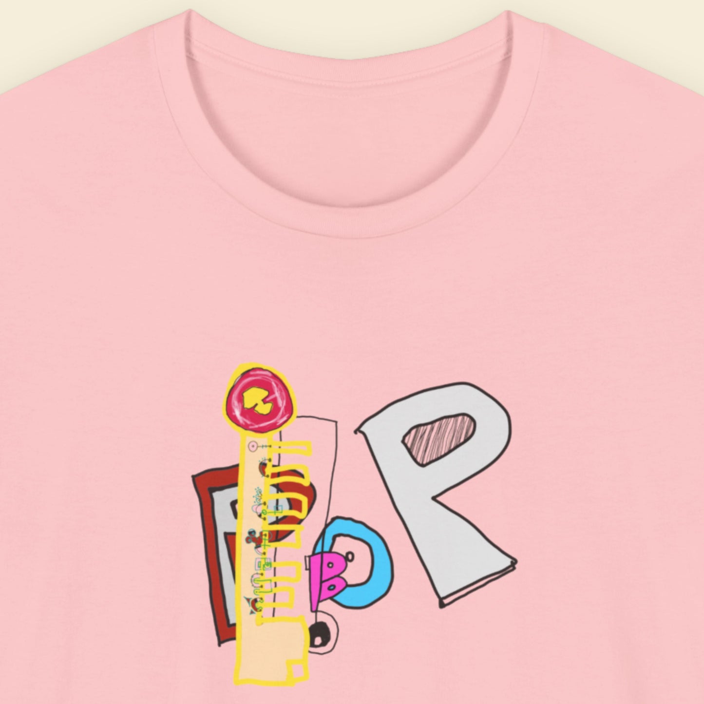 Pink t-shirt with a colorful abstract trash graff drawing on a beige background.