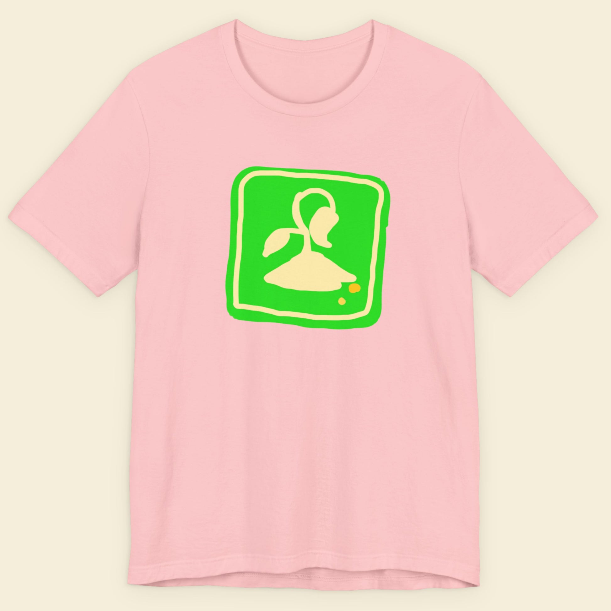 Pink t-shirt with a fun, colorful illustration on a beige background.