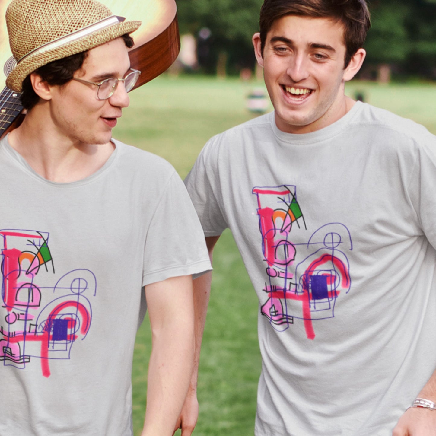 Two people wearing gray t-shirts with colorful abstract designs outdoors.