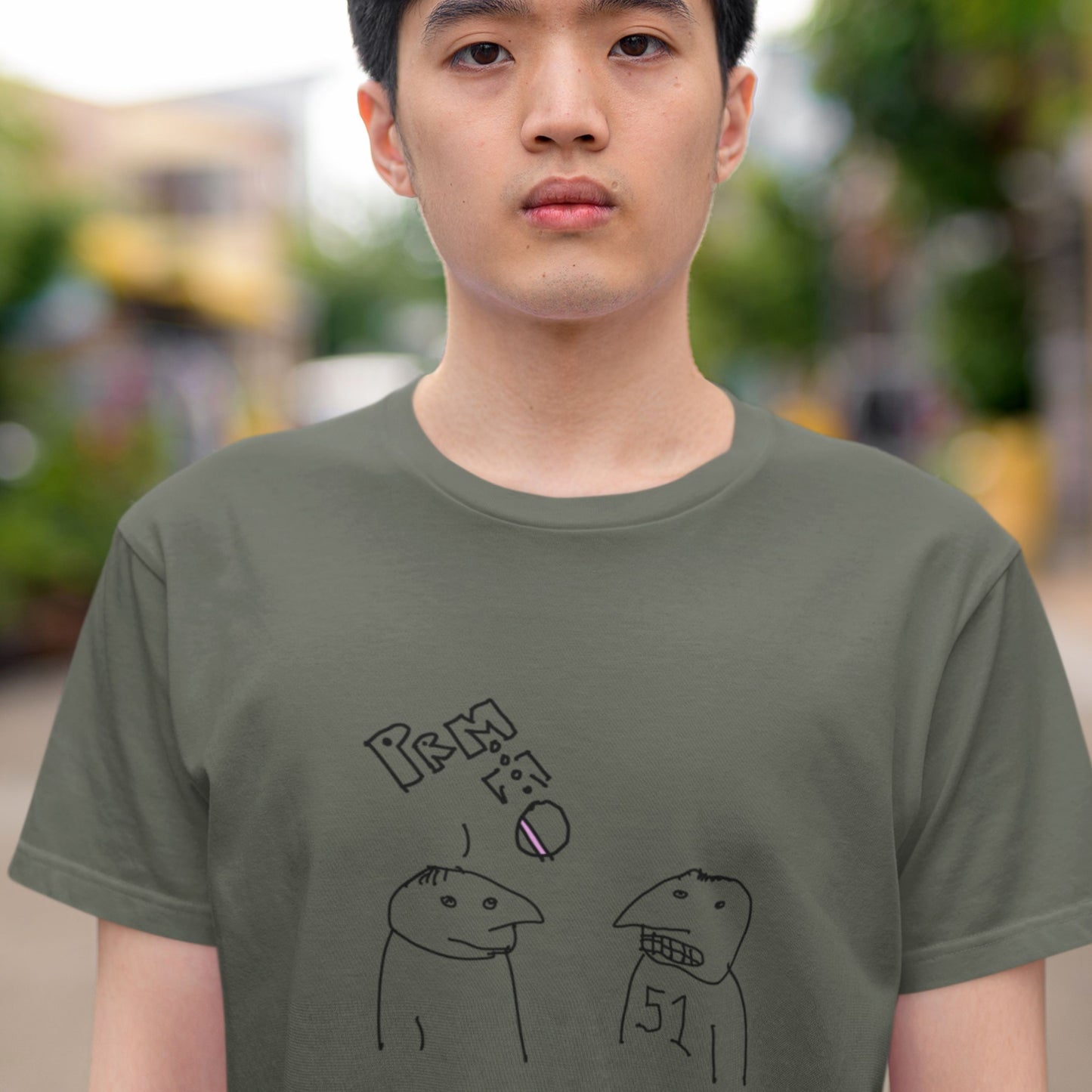 Man wearing an army green t-shirt with a colorful abstract drawing outdoors.