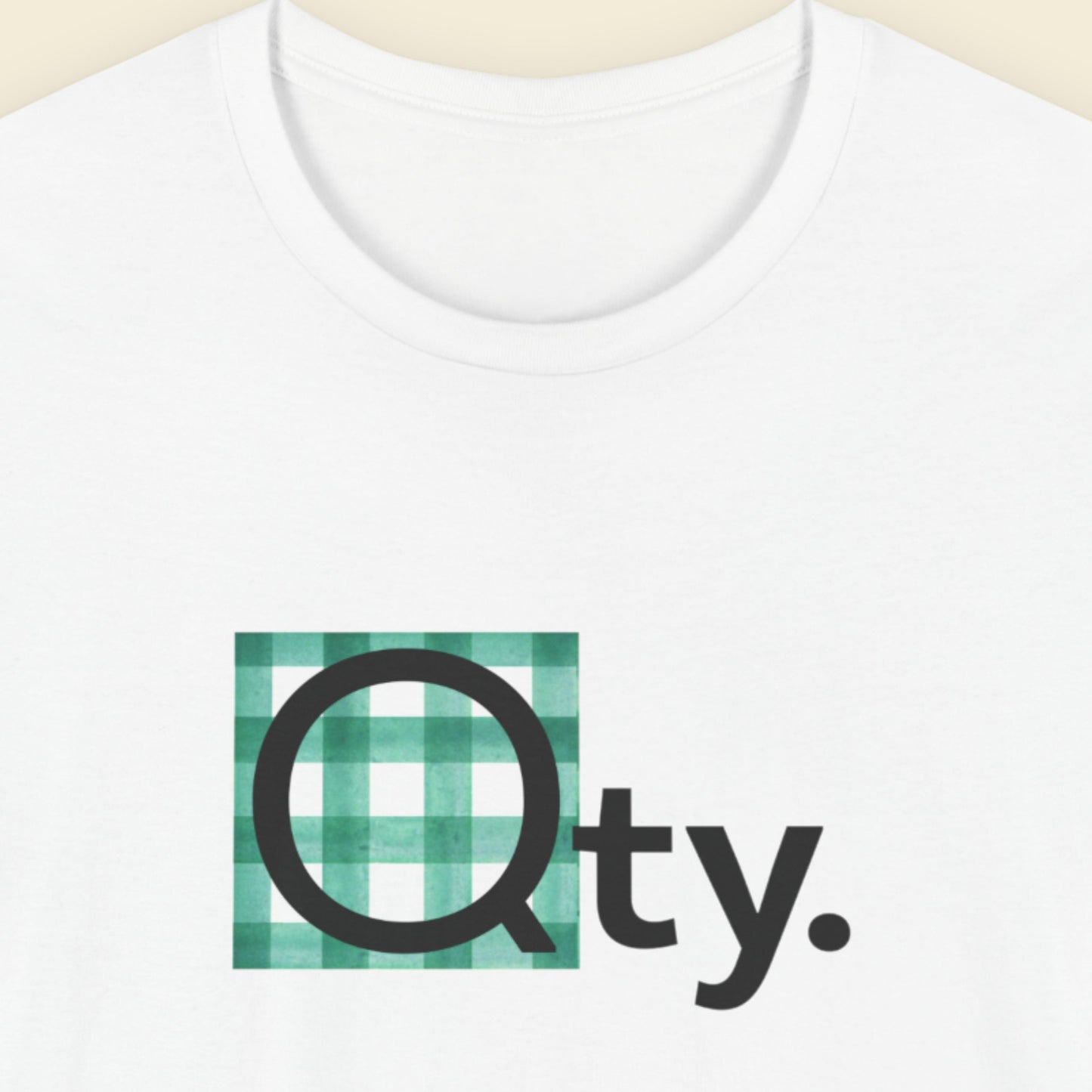 White t-shirt with a green and black logo on a beige background.