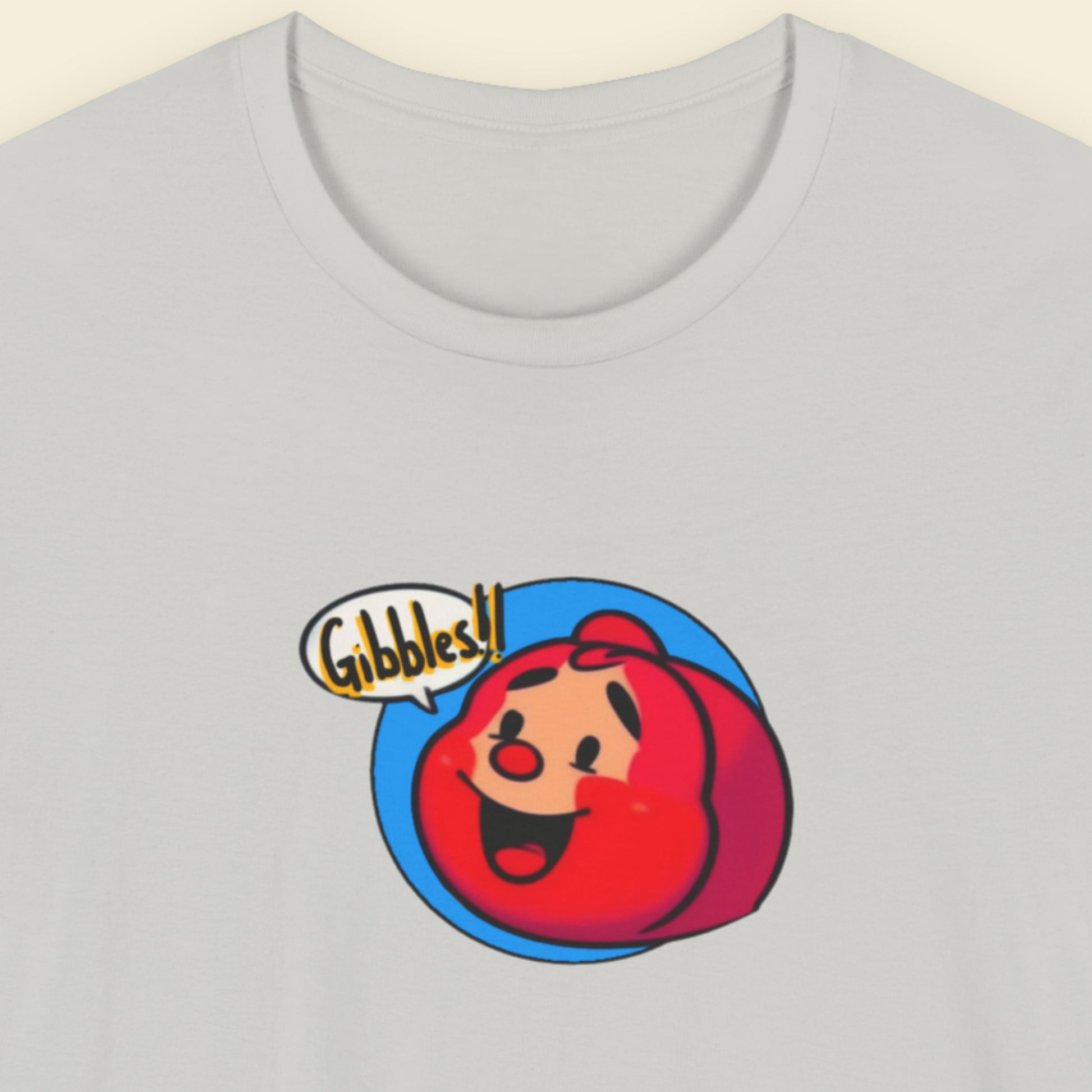 Light grey t-shirt with a fun, colorful cartoon character illustration on a beige background.
