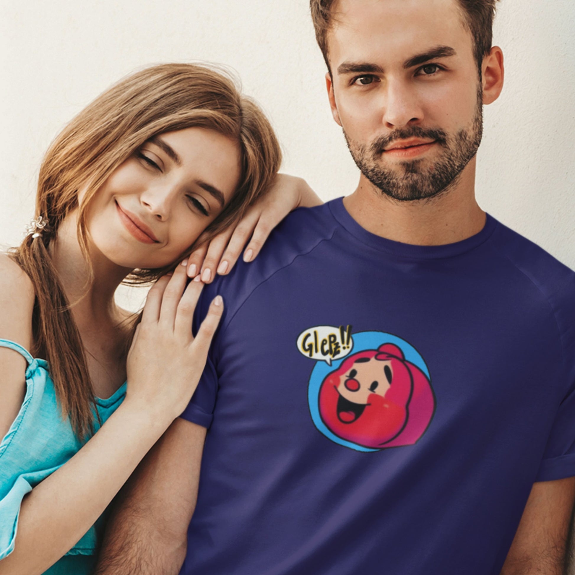 Man and his woman wearing a navy blue t-shirt with a fun, colorful Red Head cartoon illustration on a grey background.