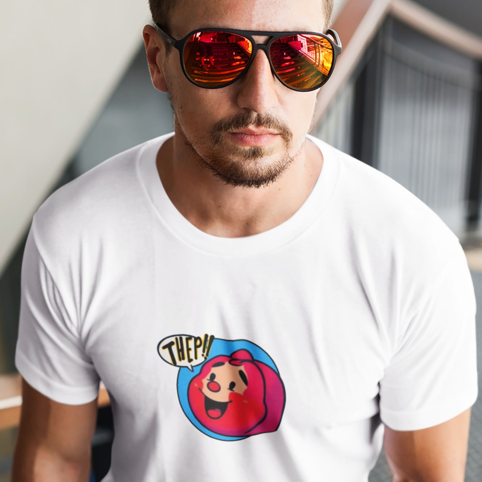 Man in a stairway wearing a white t-shirt with a fun, colorful RedHead cartoon illustration.