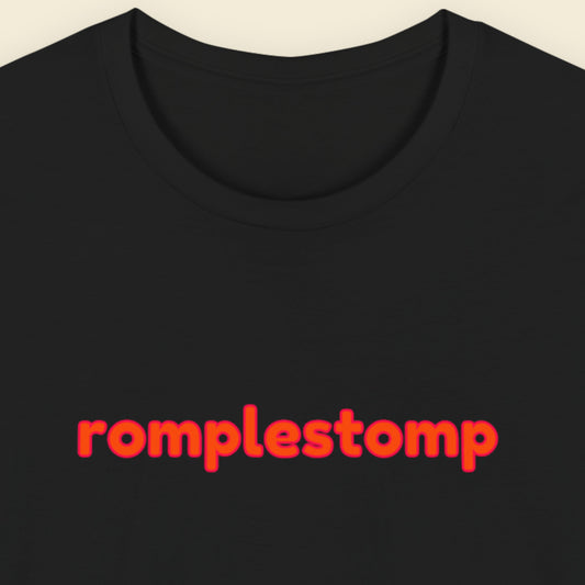 Black t-shirt with multicolored 'romplestomp' text on a beige background.