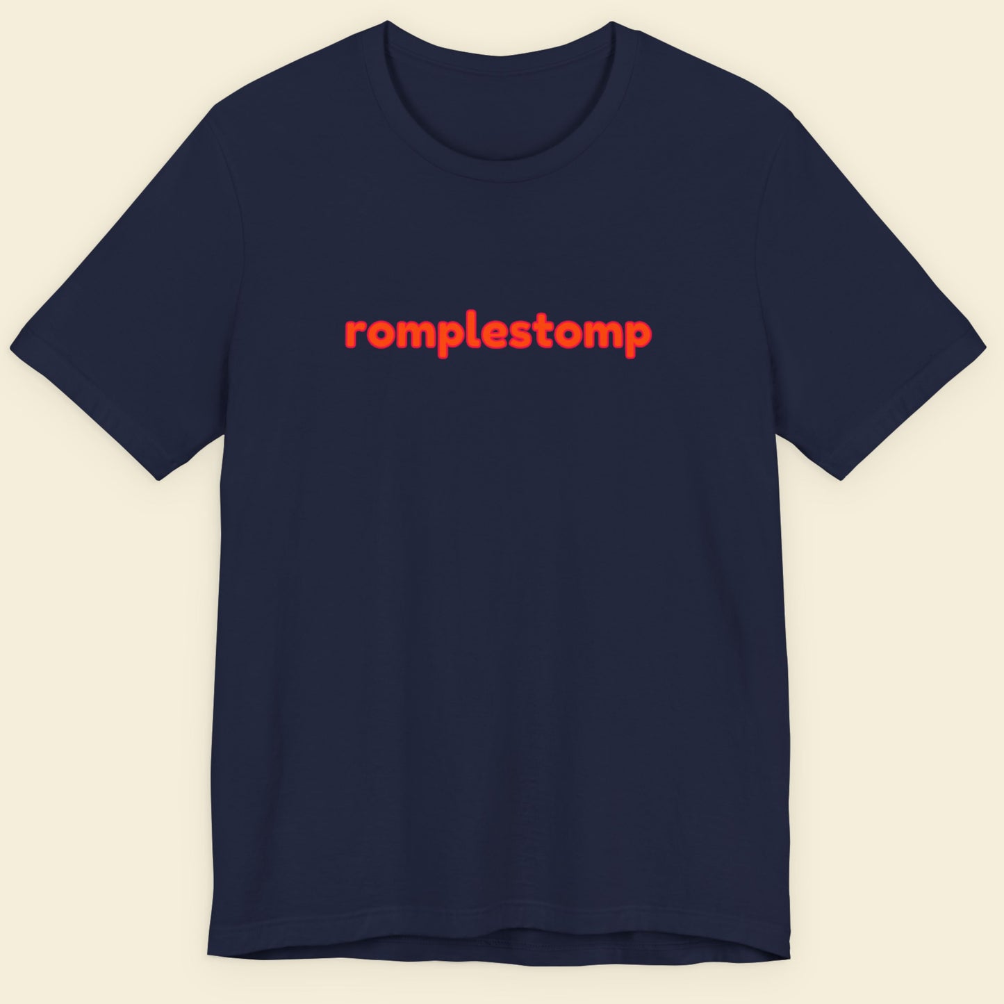 Navy blue Black t-shirt with multicolored 'romplestomp' text on a beige background.