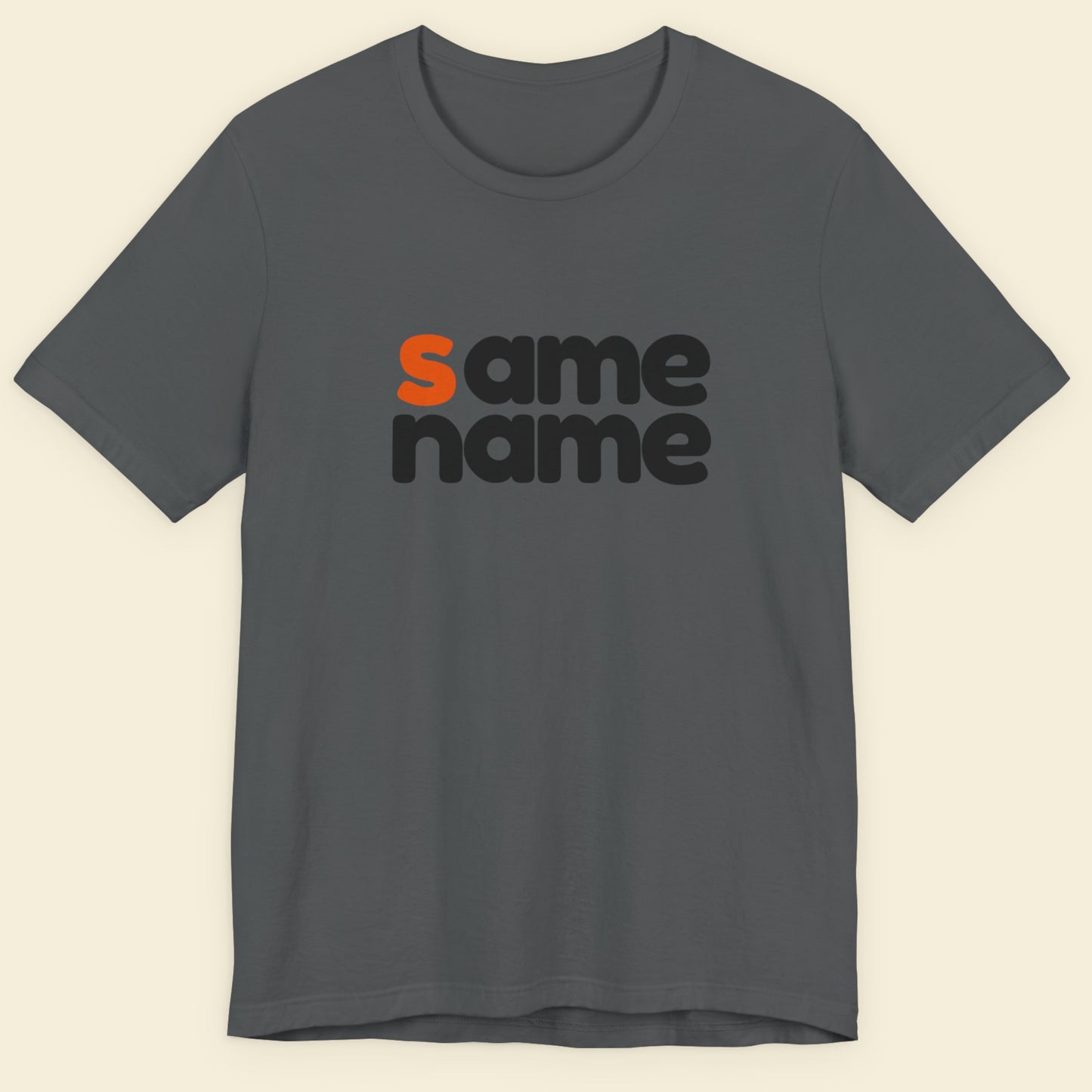 Gray t-shirt with 'same name' text in black and orange on a beige background.
