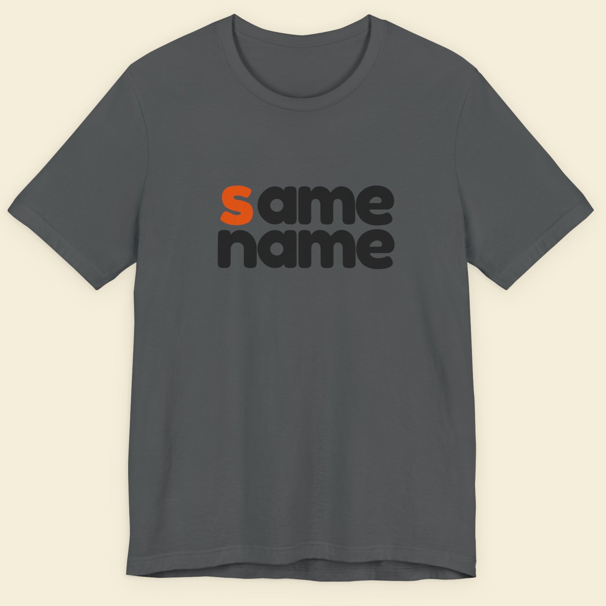 Gray t-shirt with 'same name' text in black and orange on a beige background.