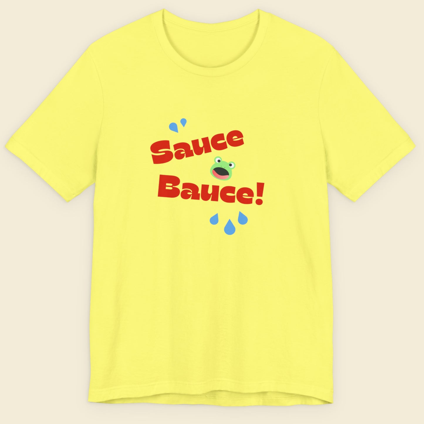 Yellow t-shirt with 'Sauce Bauce!' text and cartoon frog graphic on a beige background.