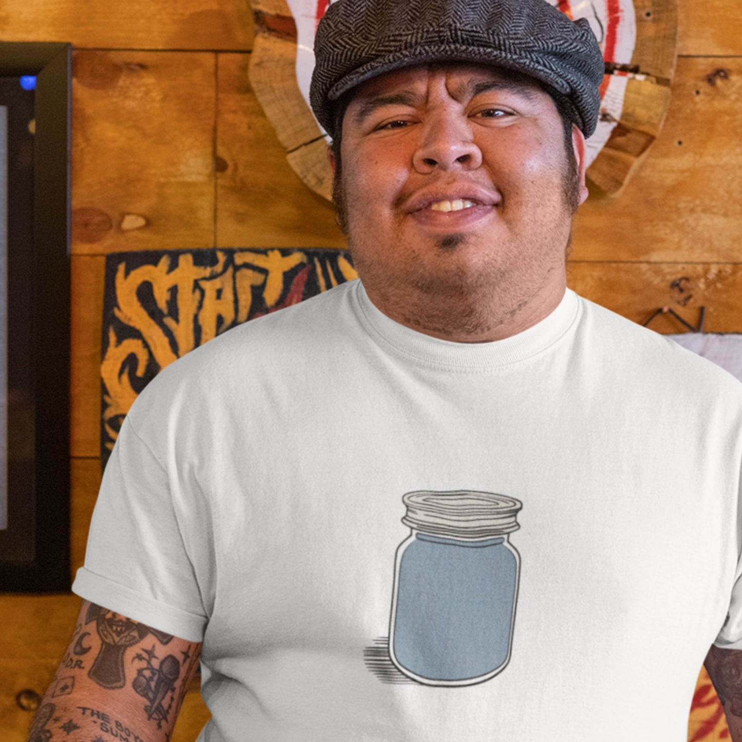 Man wearing a white t-shirt with a jar design in a casual setting